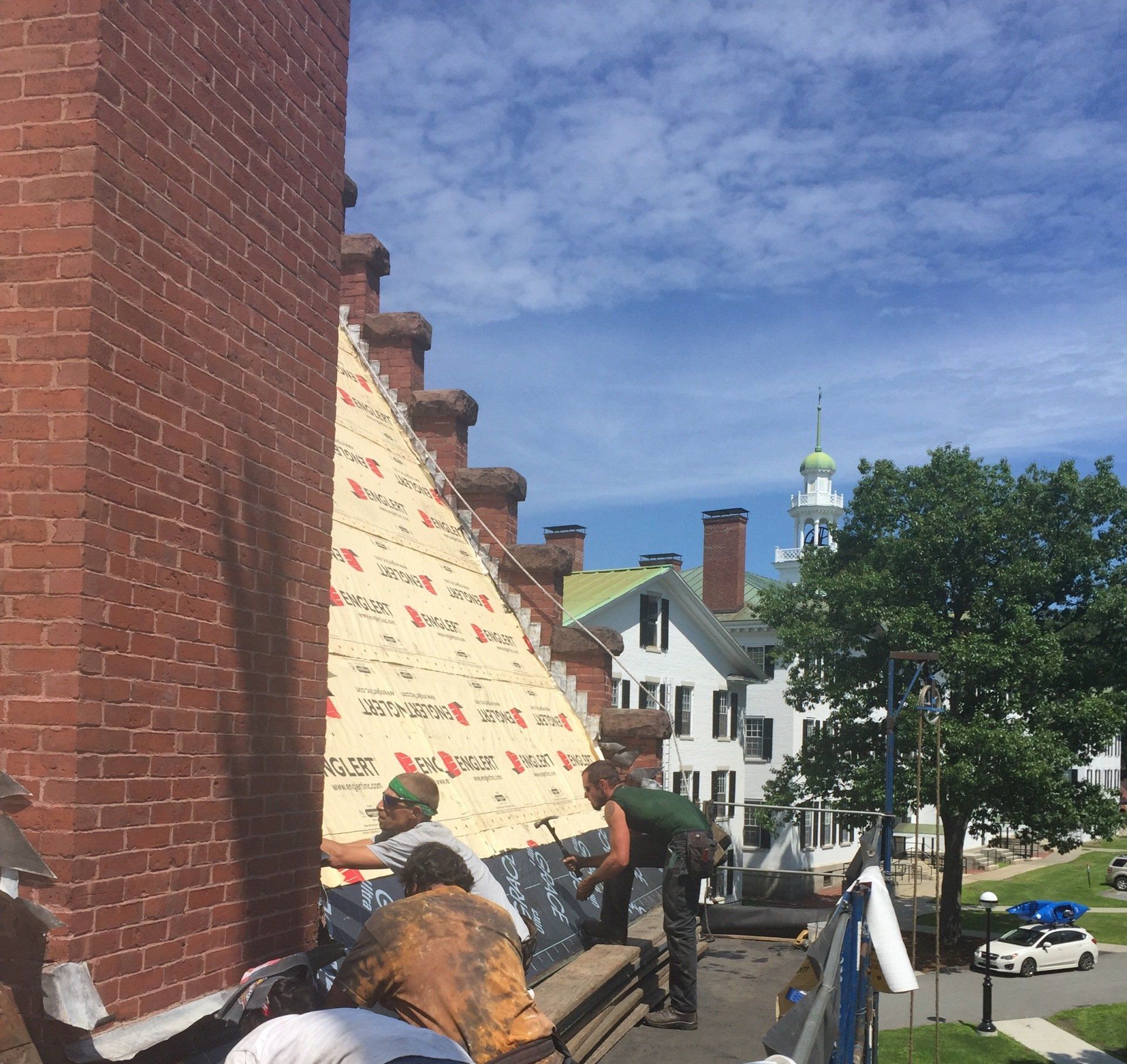 A group of people are working on a brick building