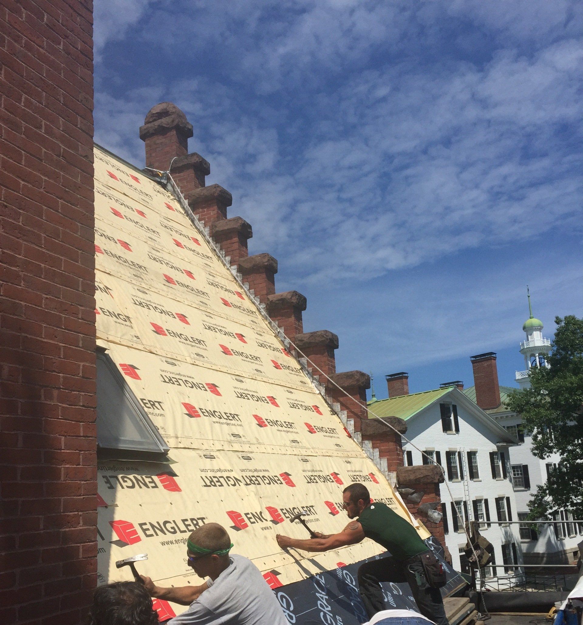 A group of men are working on a large roof