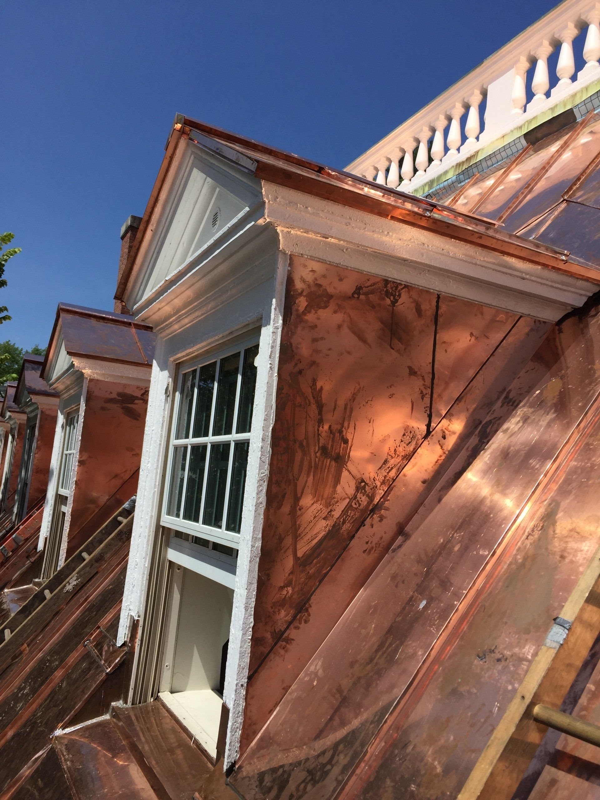 A copper roof with a window on top of it