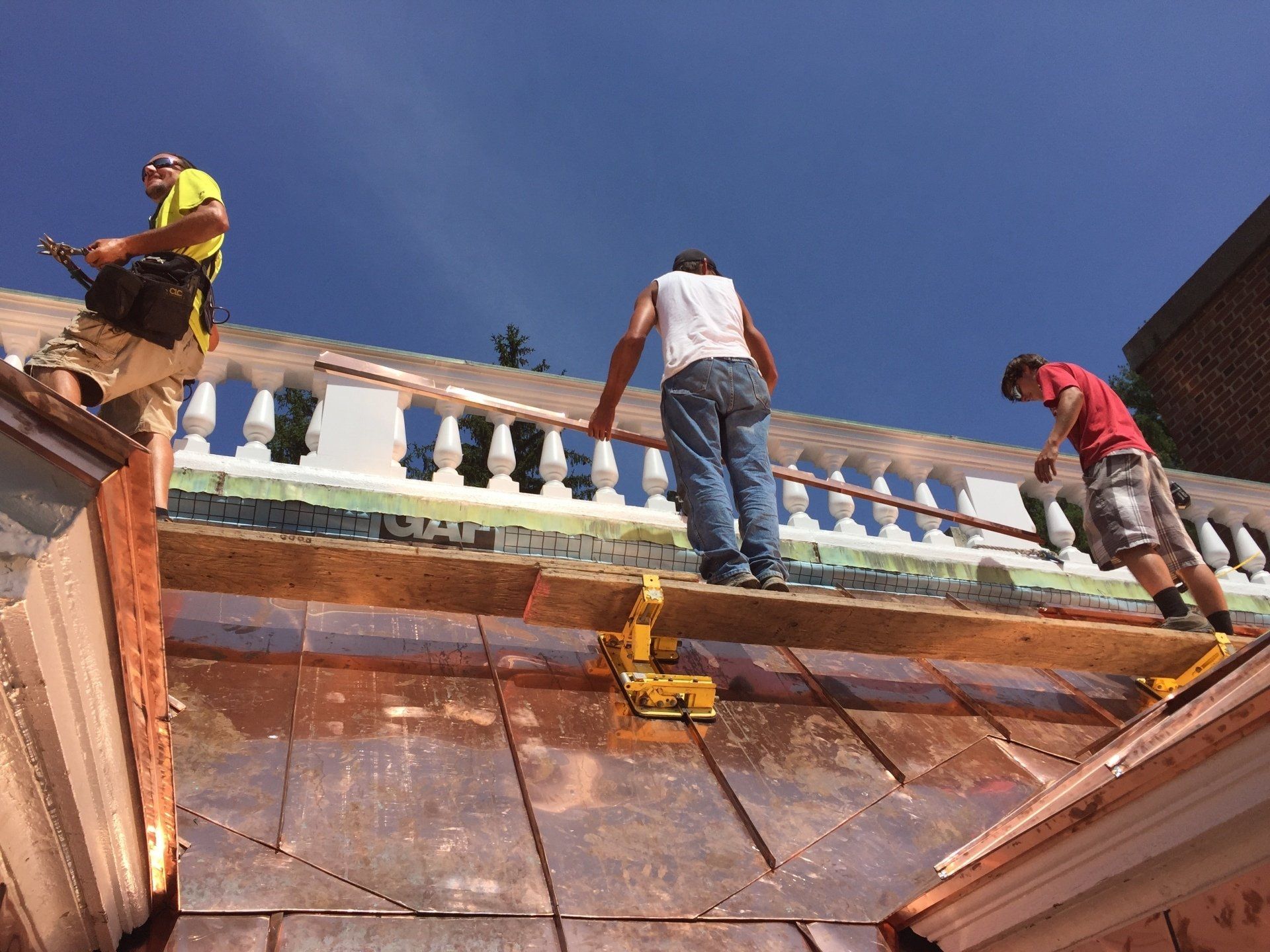 Rodd Roofing employees putting a copper roof on a commercial budling