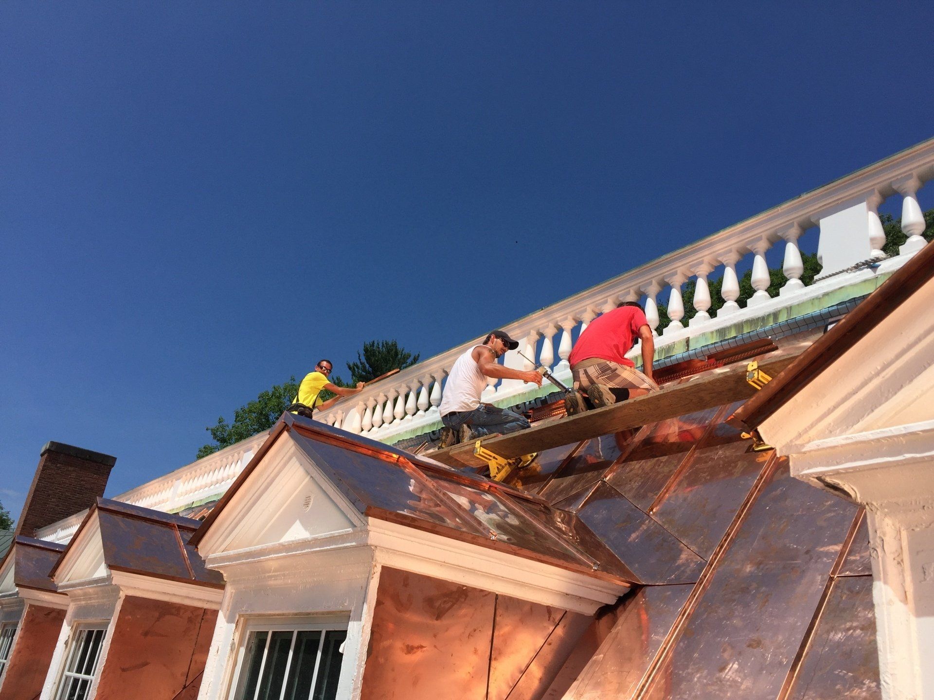 A group of people are working on the roof of a building.