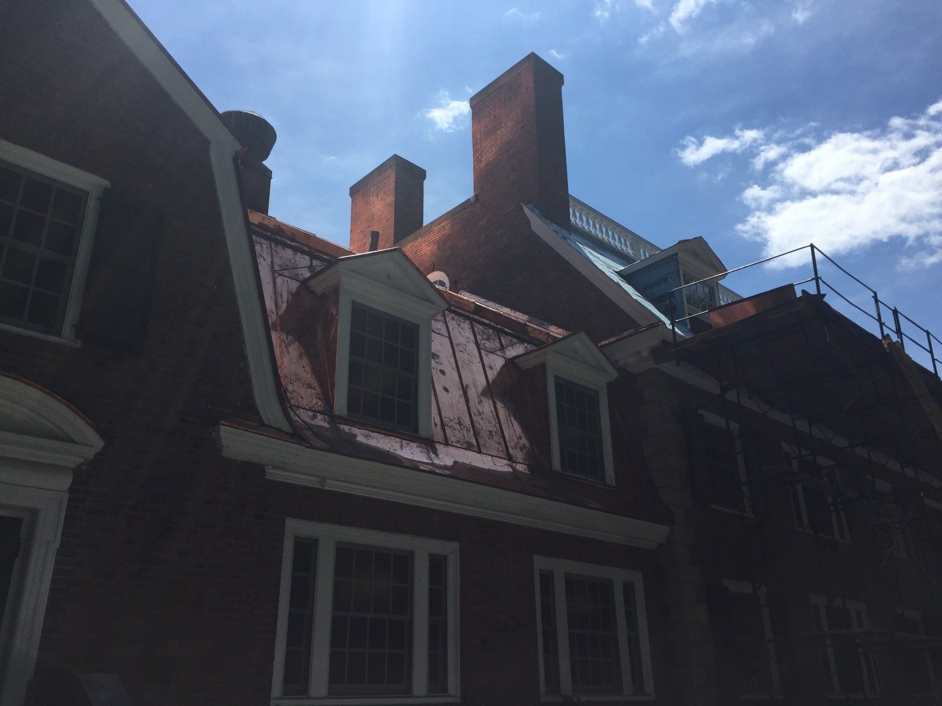 A brick building with a copper roof and chimneys