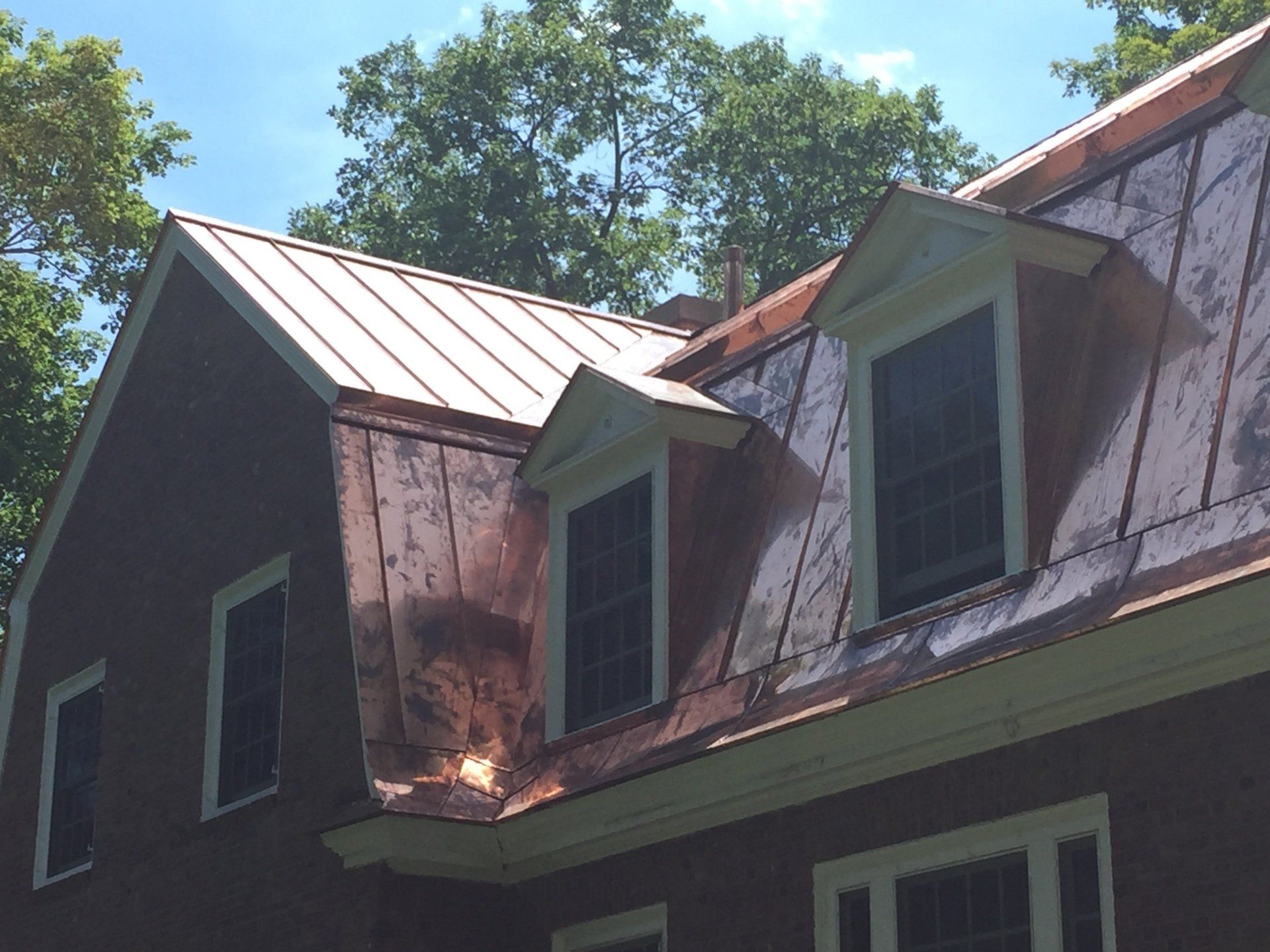 A house with a copper roof and two windows