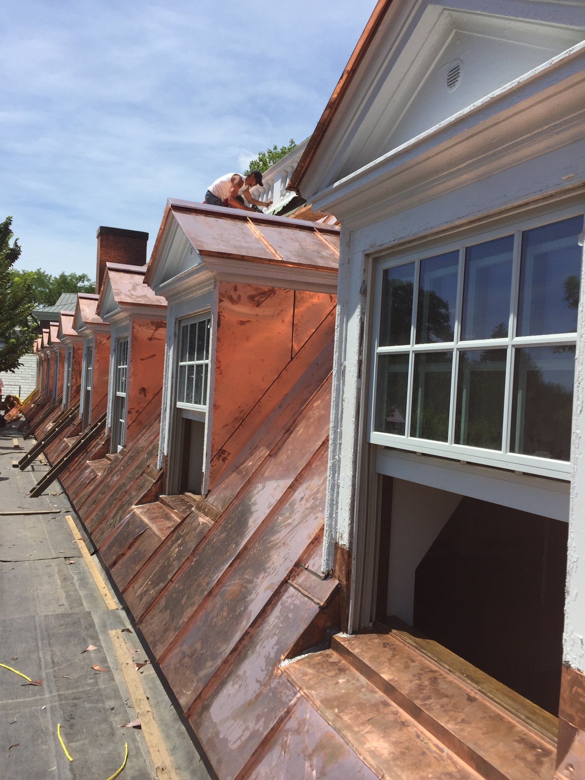 A row of buildings with copper roofs and windows