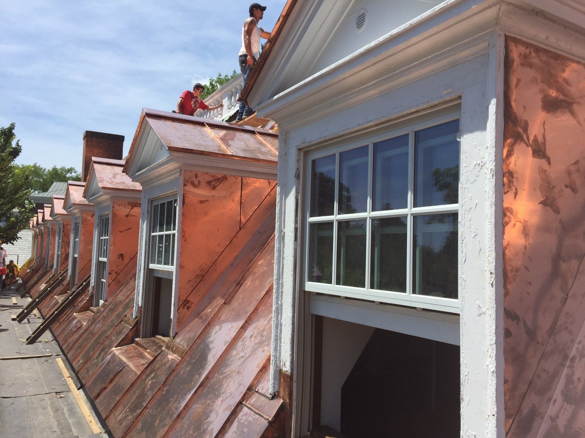 A group of people are working on the roof of a building.