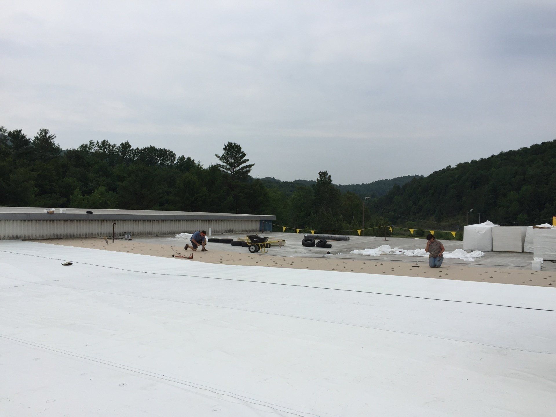 A group of people are working on a white roof.