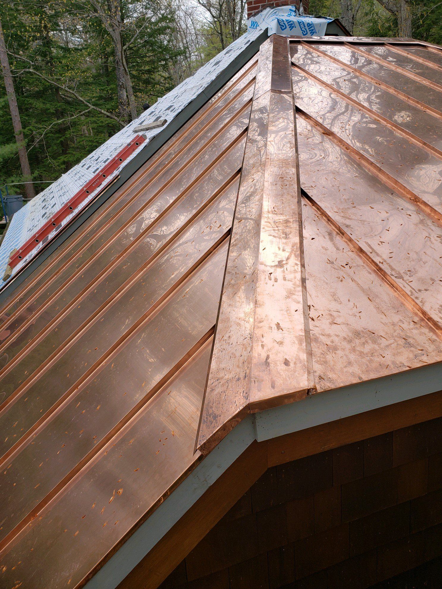 A copper roof is being installed on a house