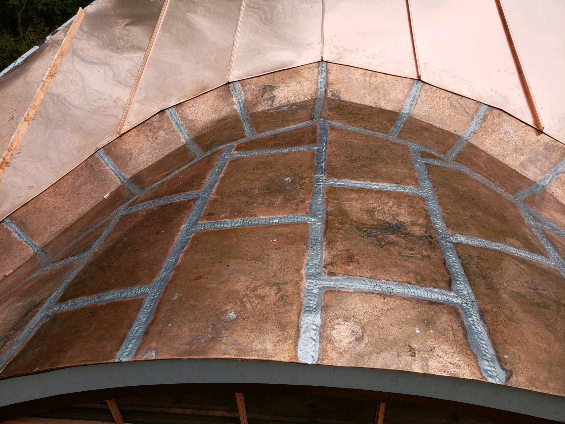 A close up of a copper roof on a building