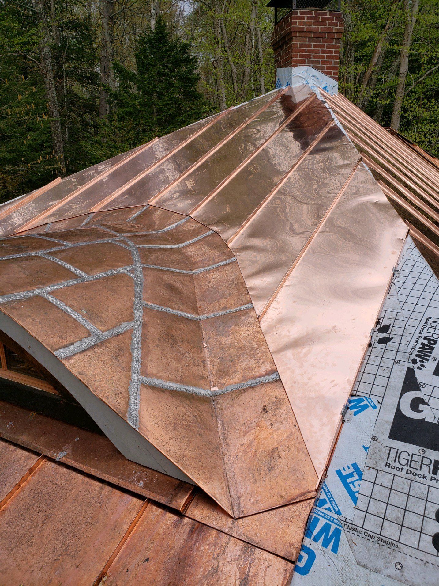 A copper roof is being installed on a house.