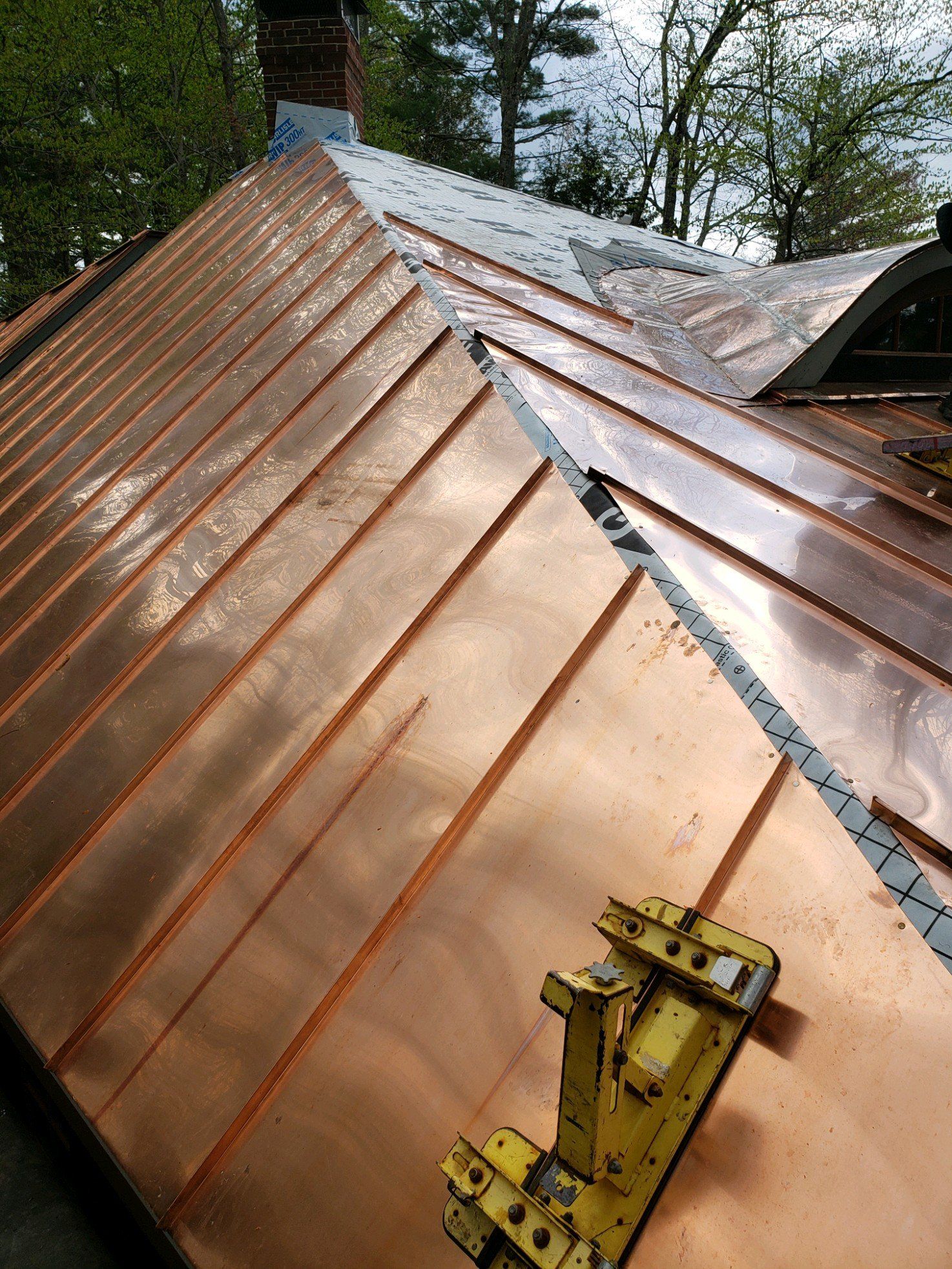 A copper roof is being installed on a house.