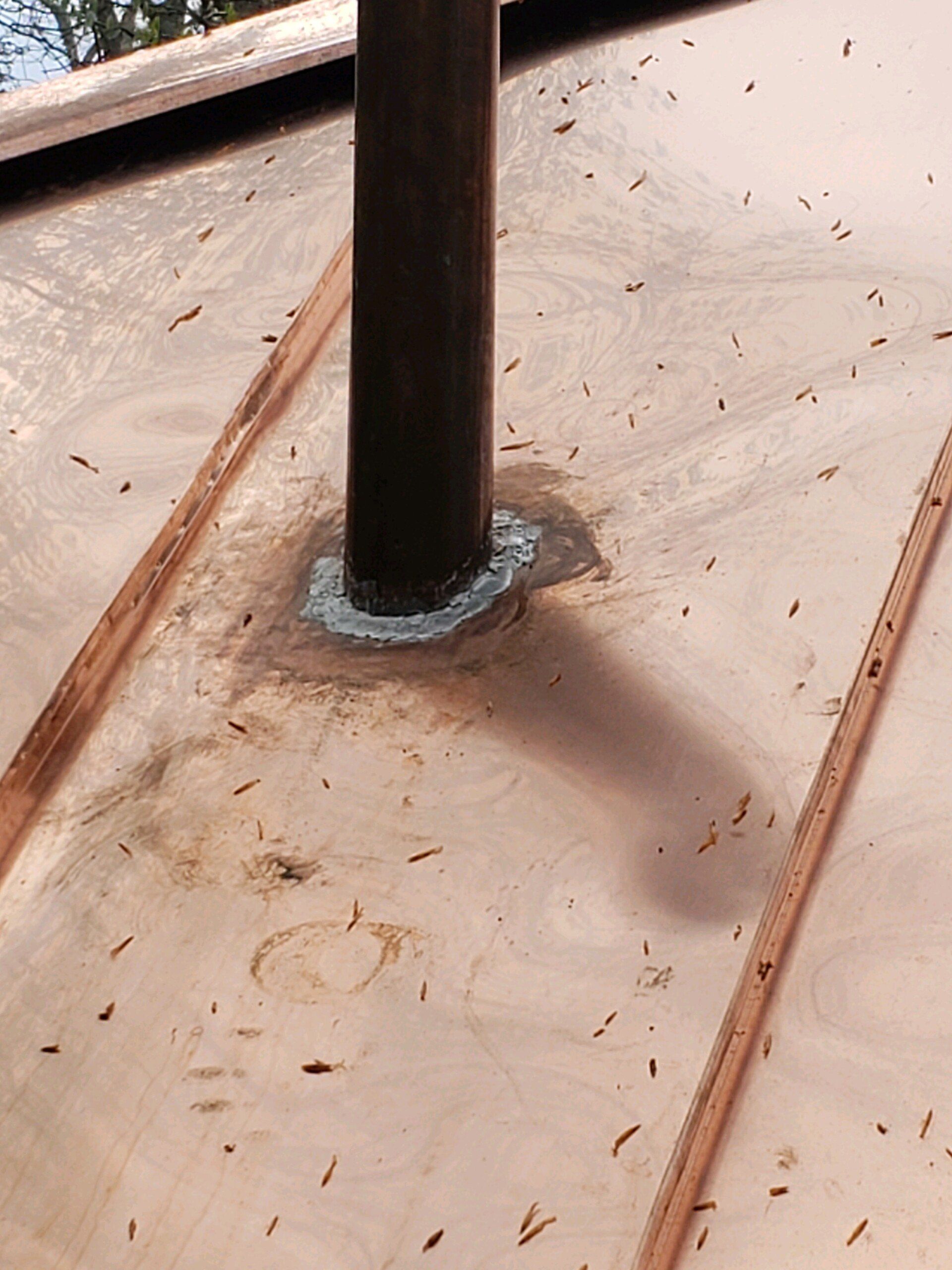 A copper roof with a pipe in the middle of it