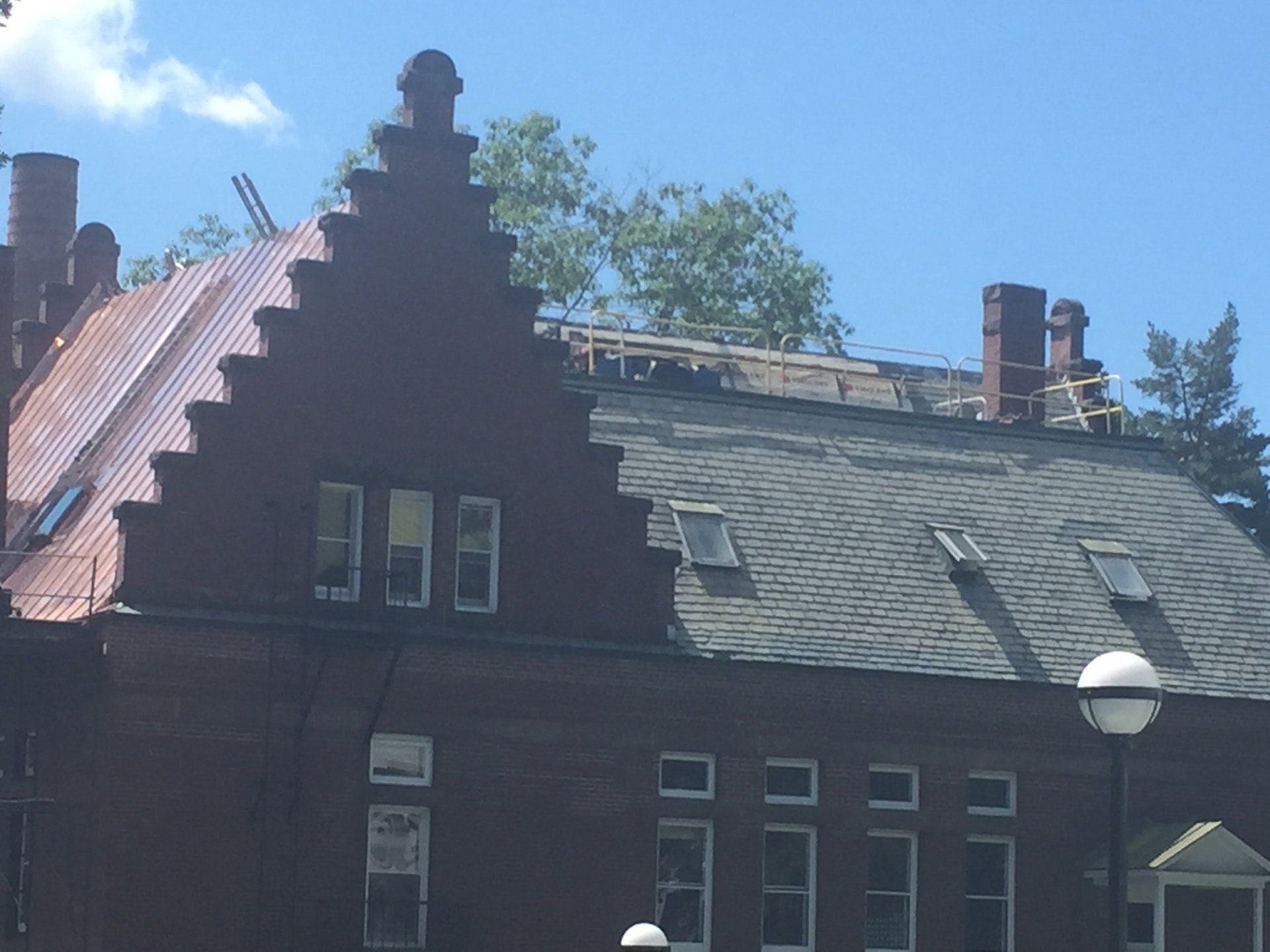 Large brick building getting a new copper roof installed