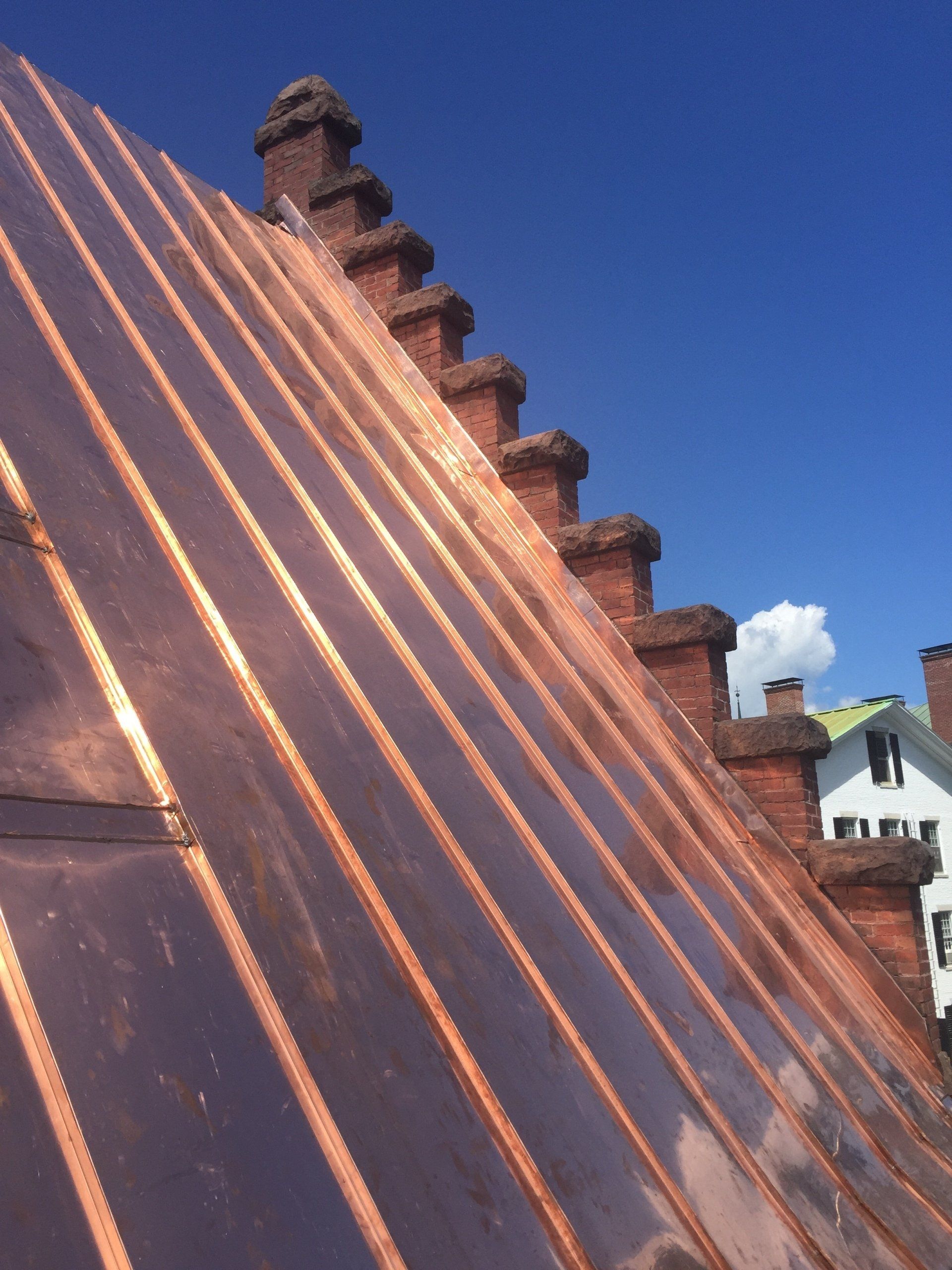 A copper roof with chimneys on top of it