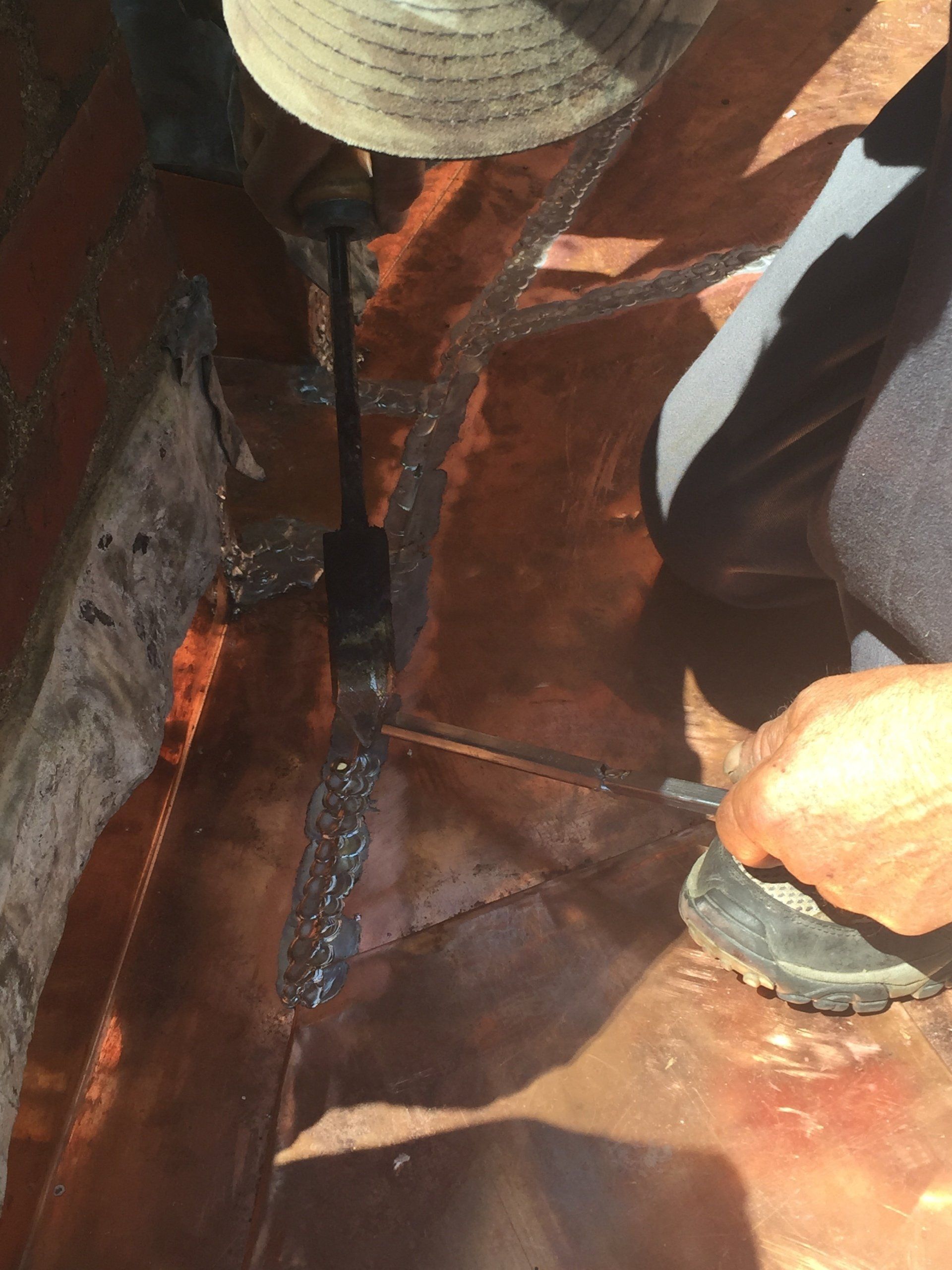 A person is cutting a piece of metal with a saw.