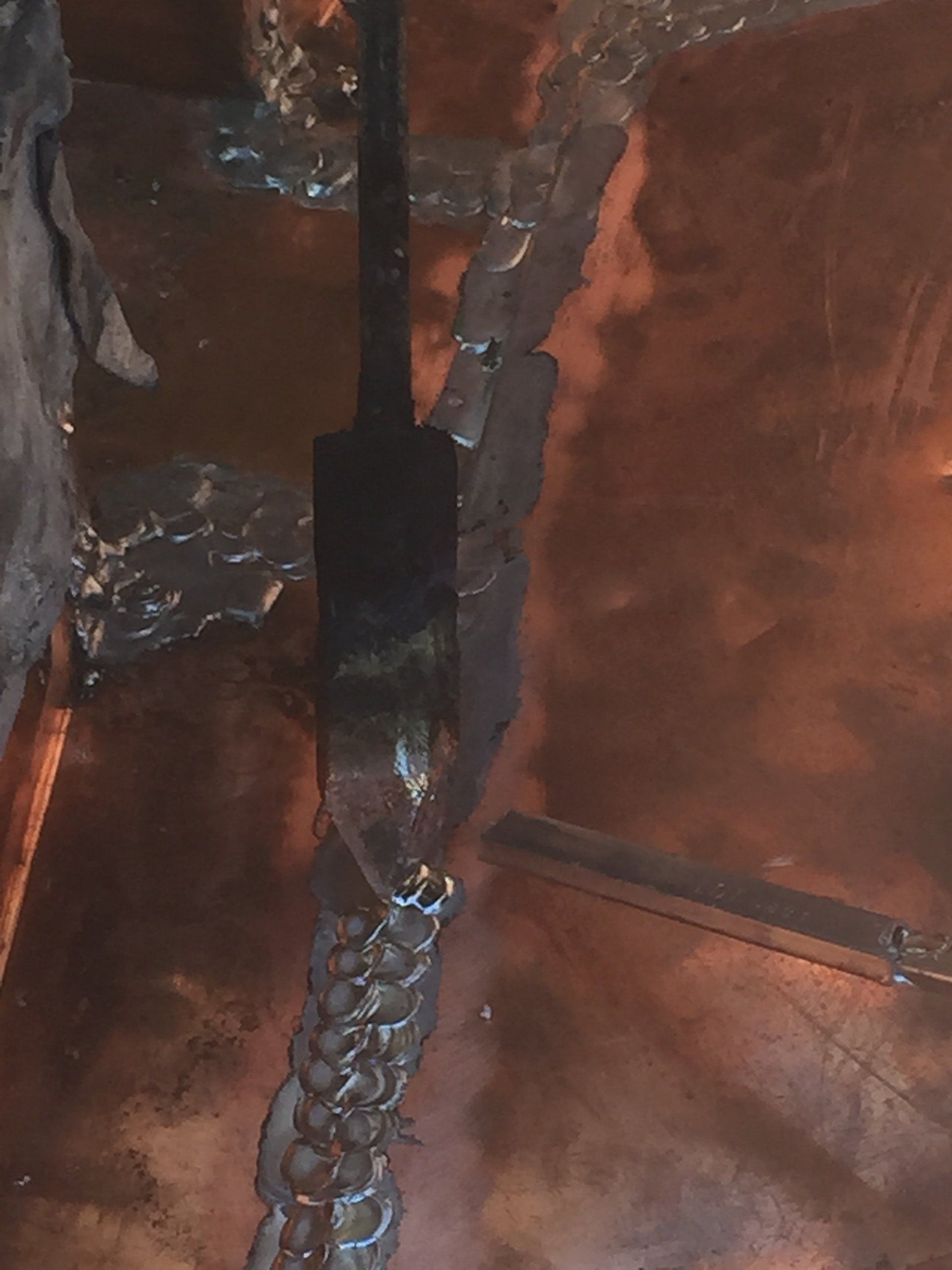 A close up of a copper surface with a black object in it