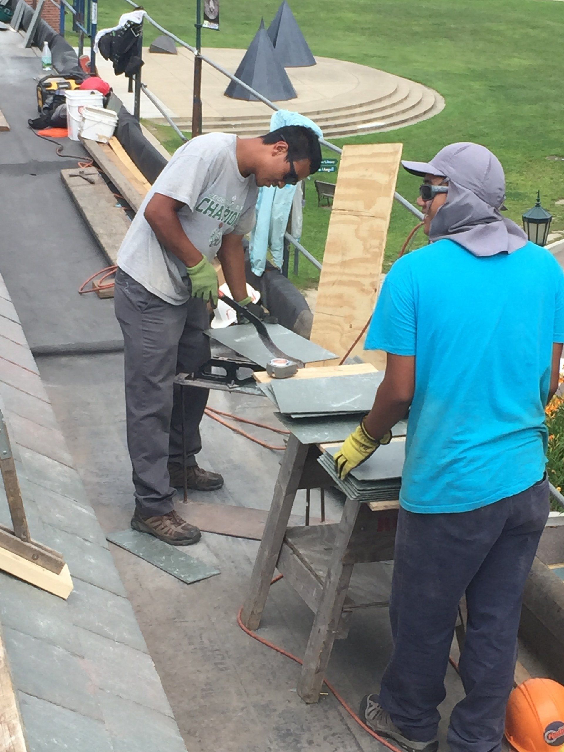 Vermont Slate Roofing experts prepare slate shingles for installation on a commercial roof