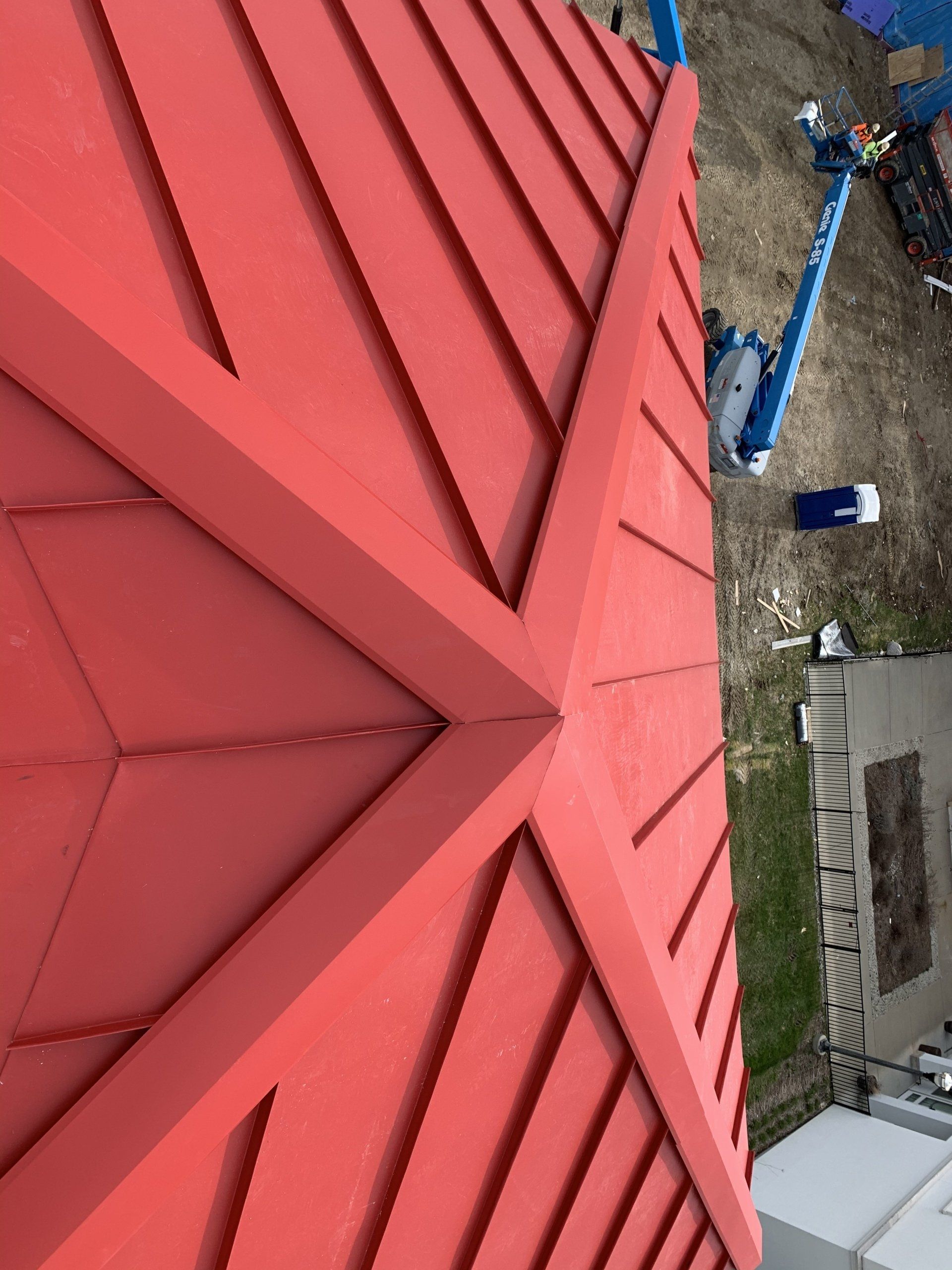 A red roof with a blue crane in the background