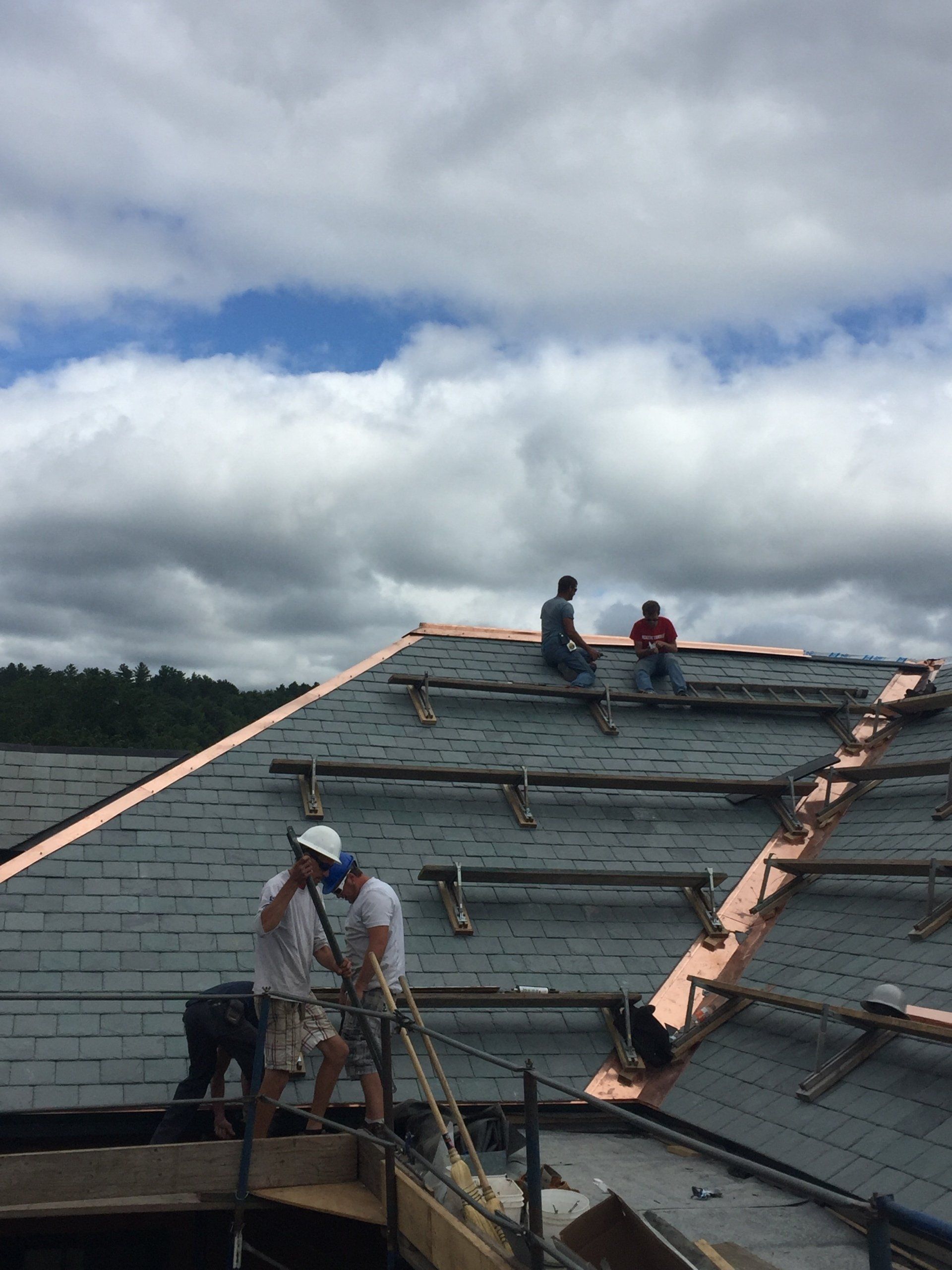 Rodd Roofing employees installing a slate roof with copper valleys and trim