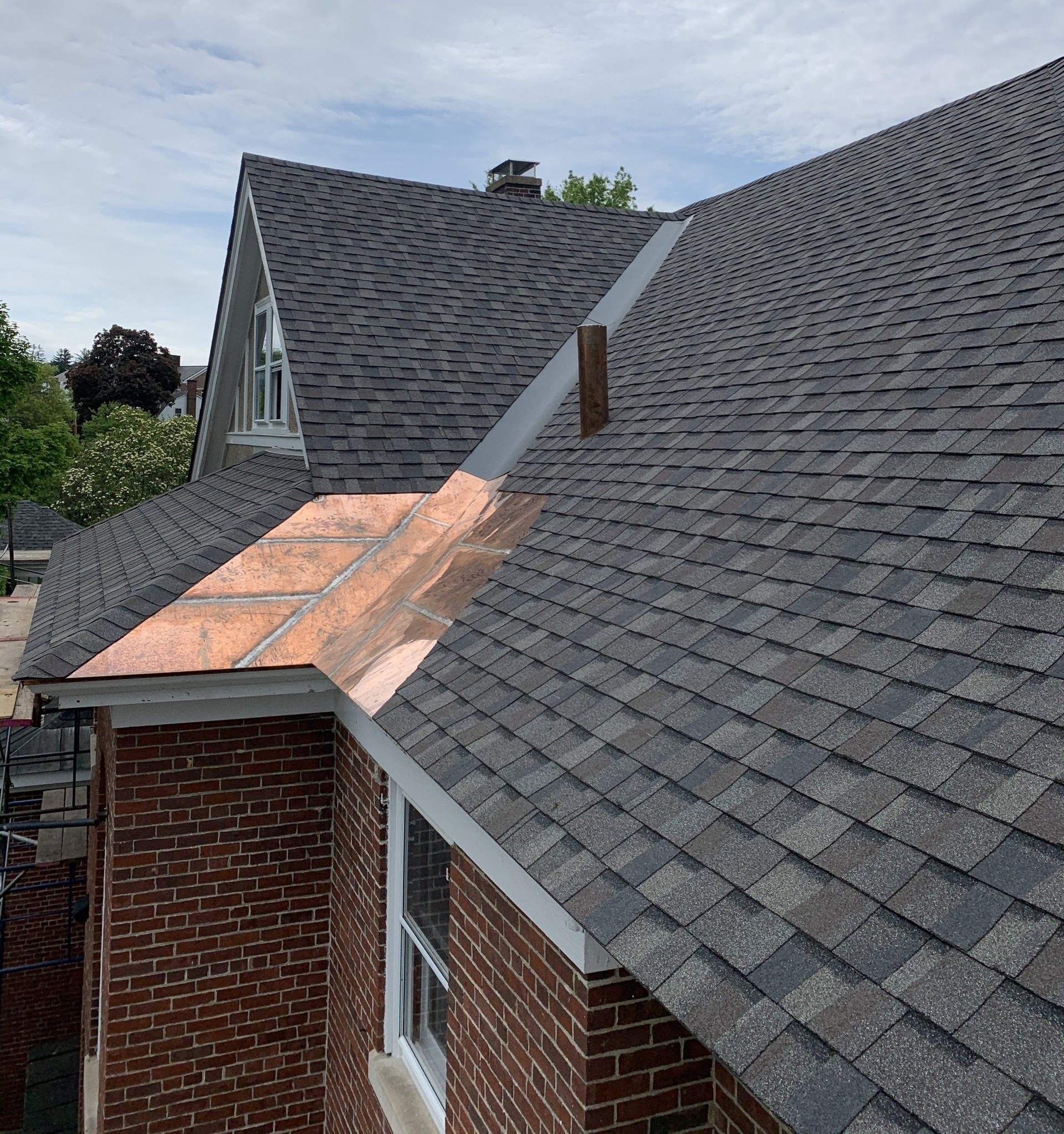 Roof with gray shingles and copper