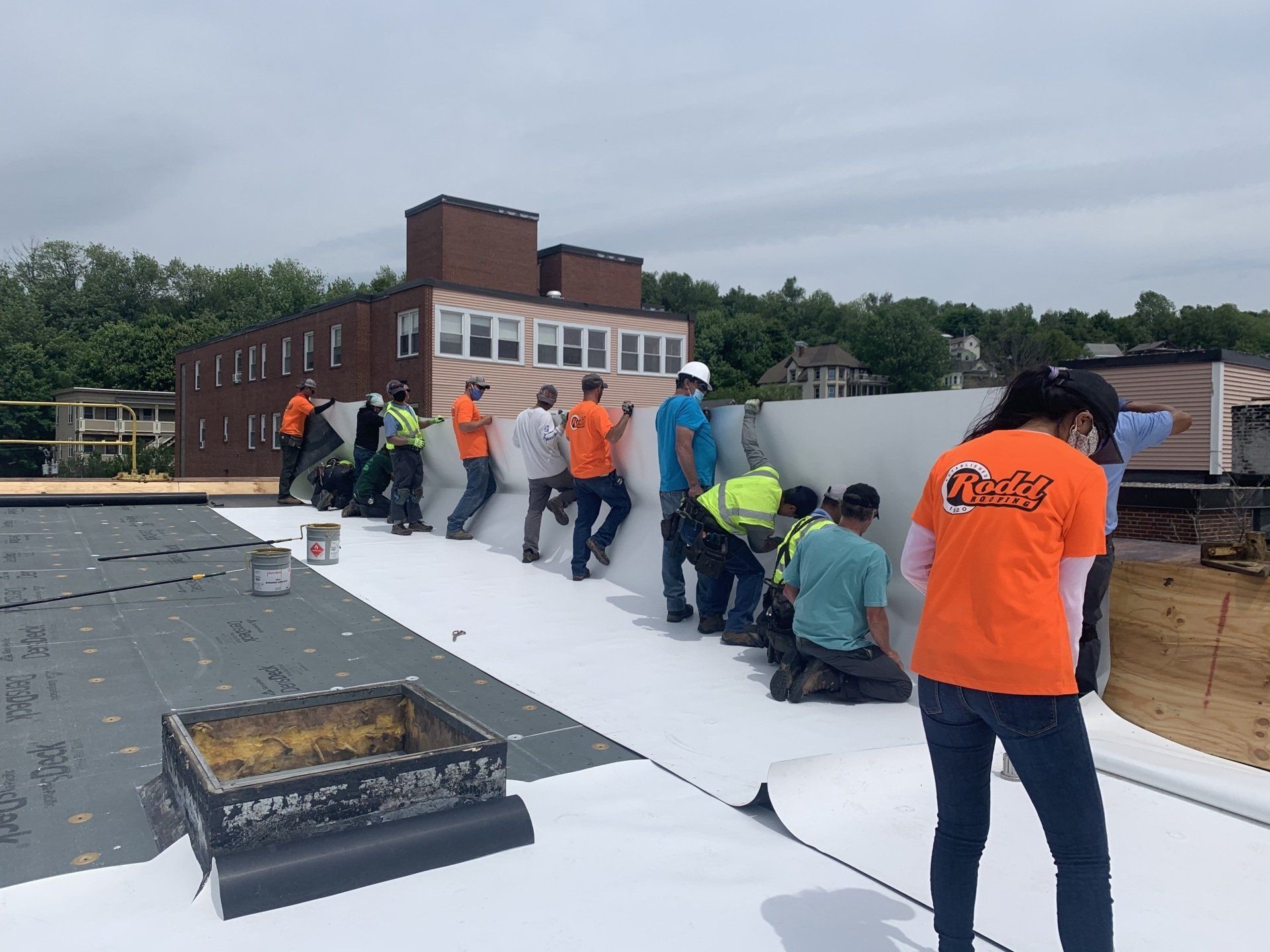 Rodd Roofing employees installing a new single-ply roof on a commercial building