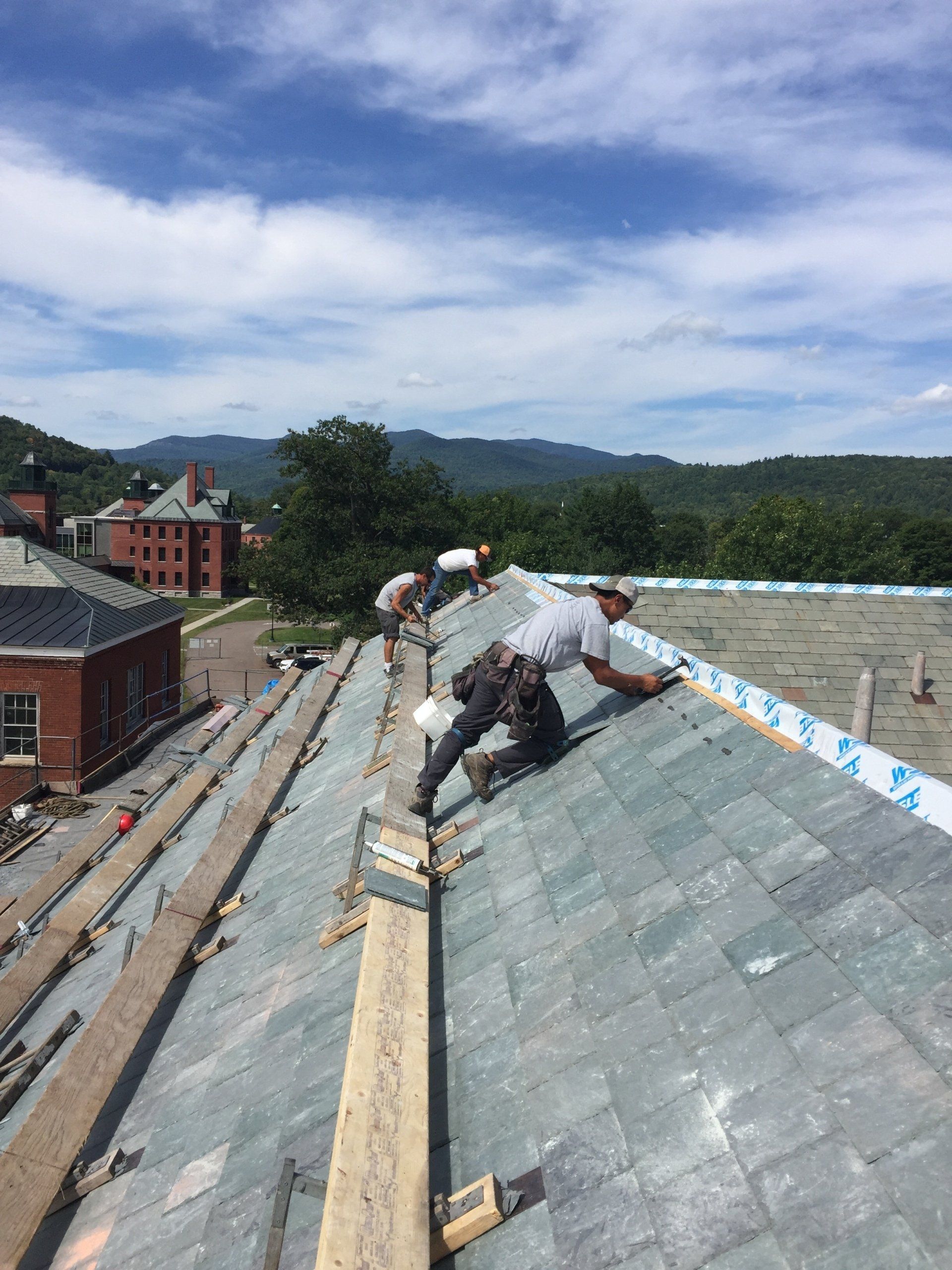A group of men are working on the roof of a building.