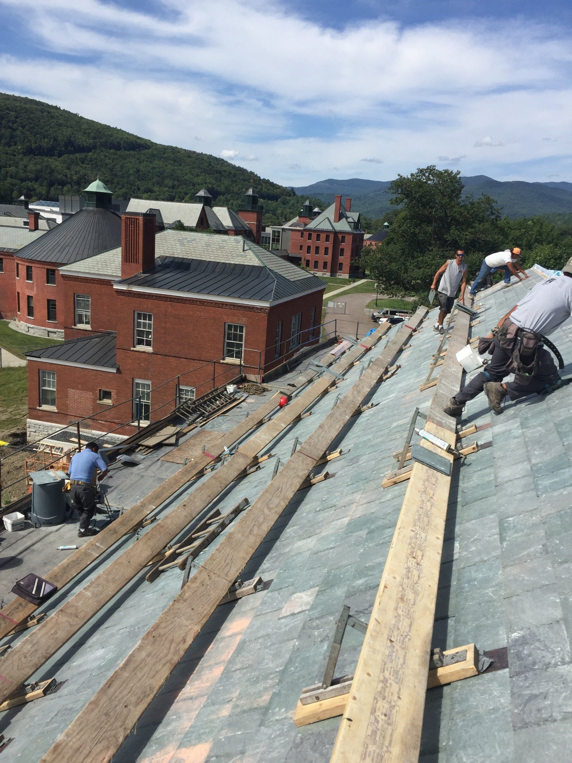 A group of people are working on the roof of a building.
