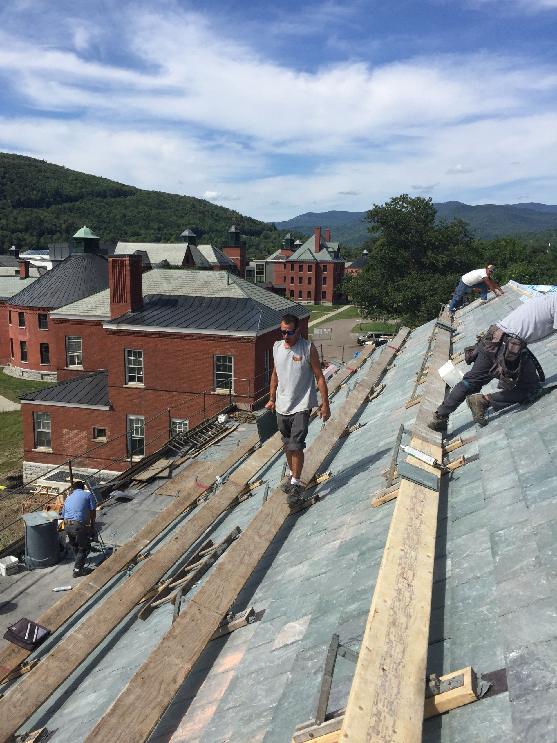 Two men are working on the roof of a building.