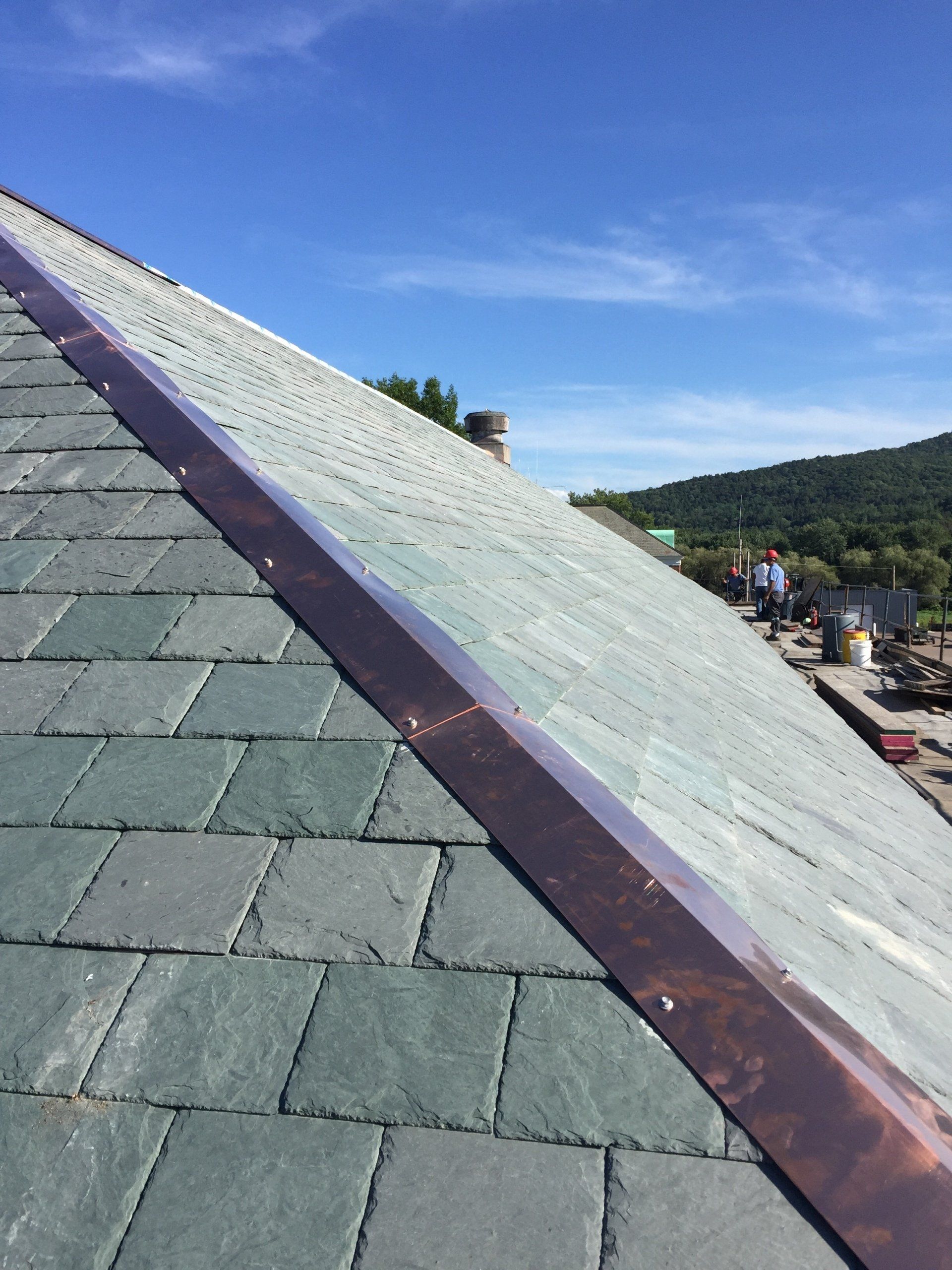A close up of a roof with a copper trim