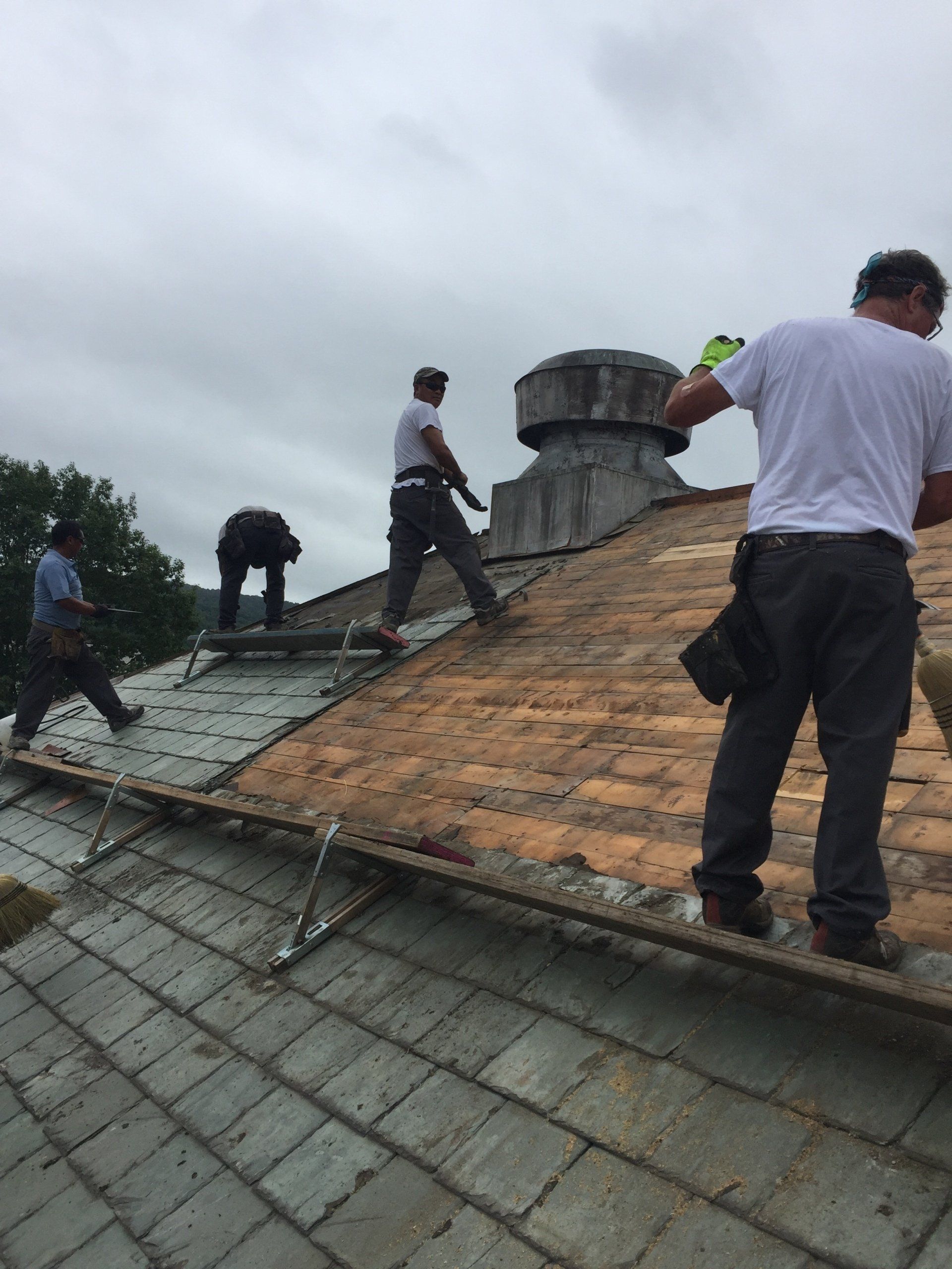 A group of men are working on the roof of a building