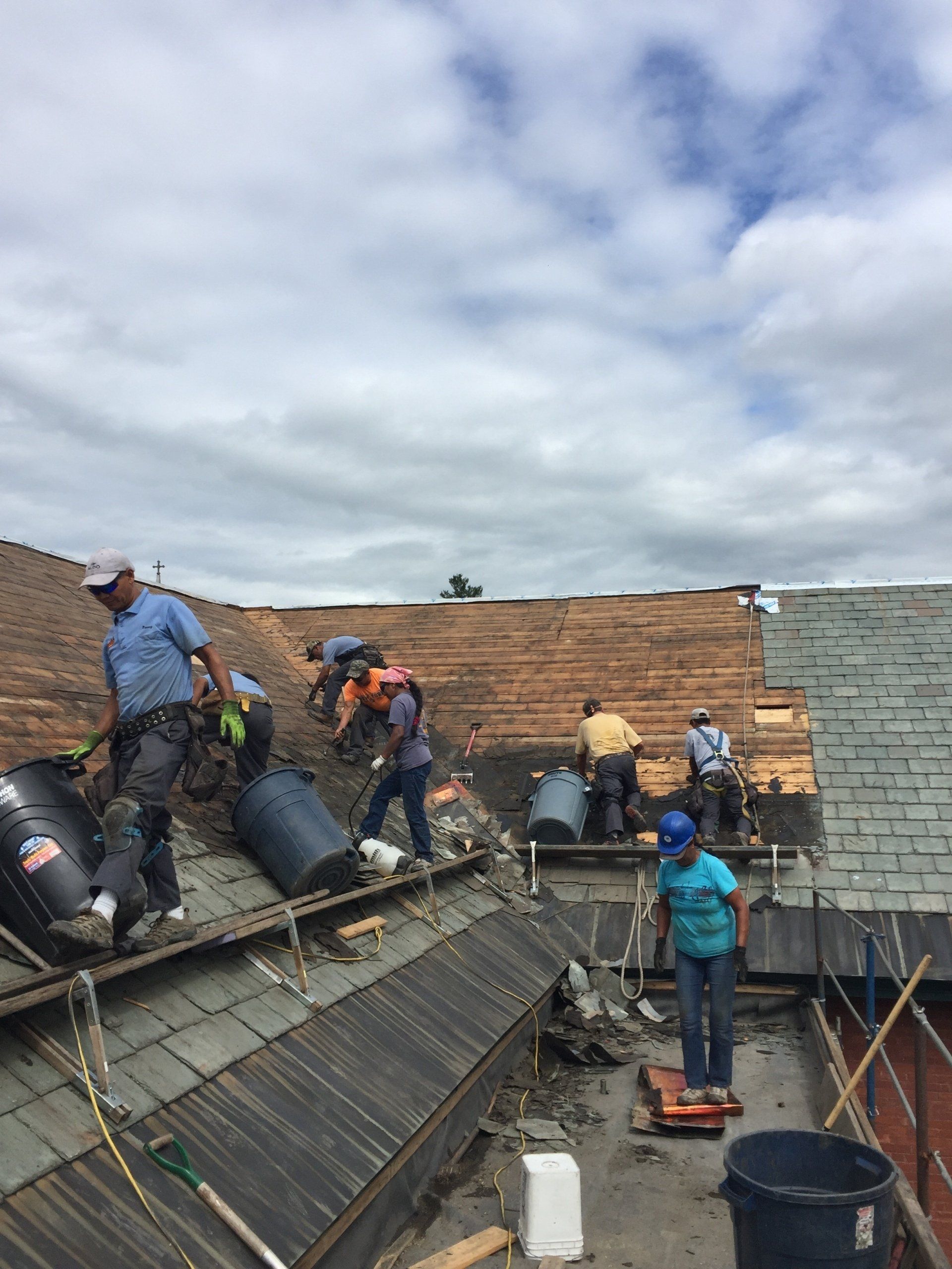 A group of people are working on the roof of a building.