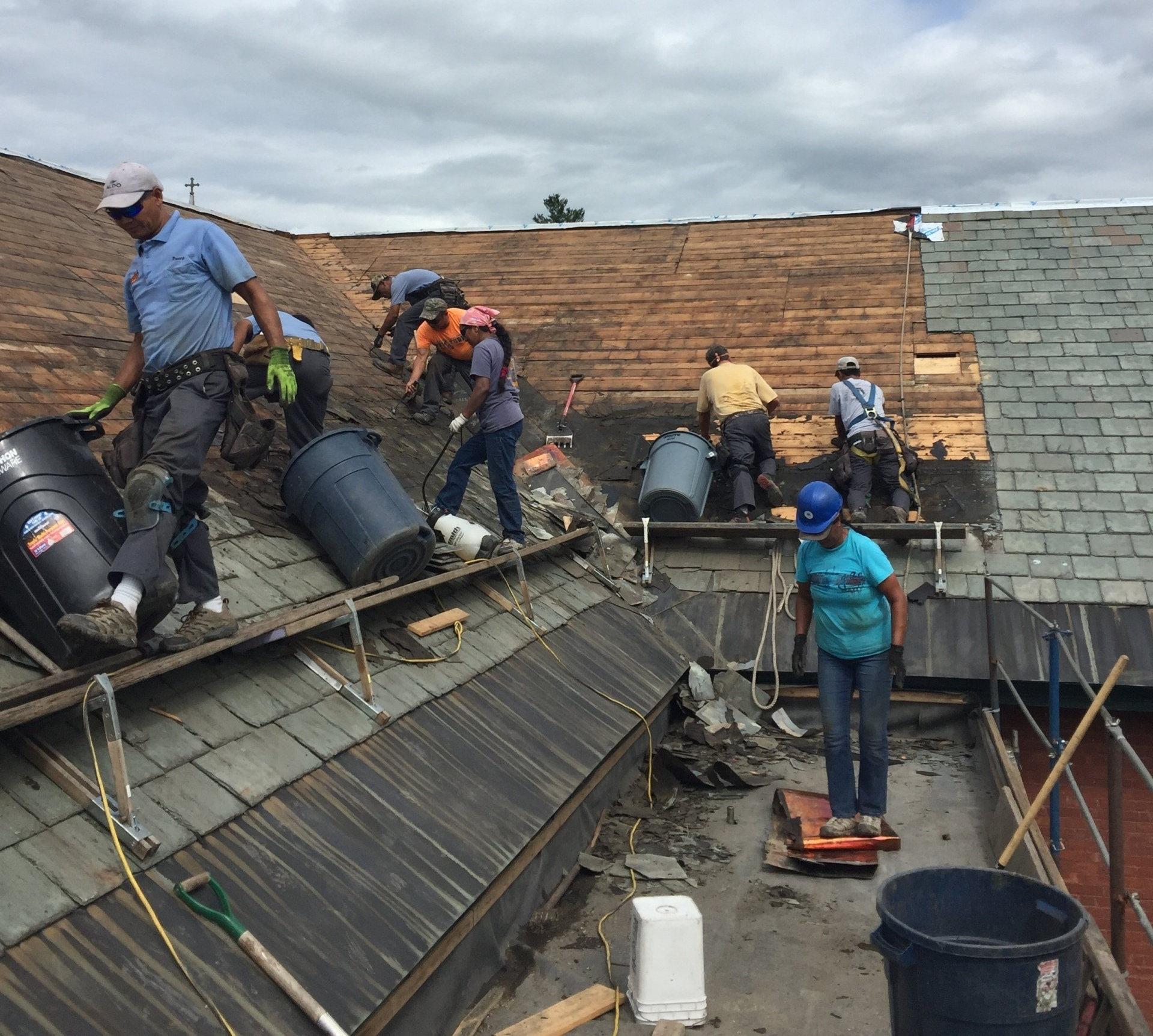 A group of Rodd Roofing employees are working on the roof of a building in Vermont