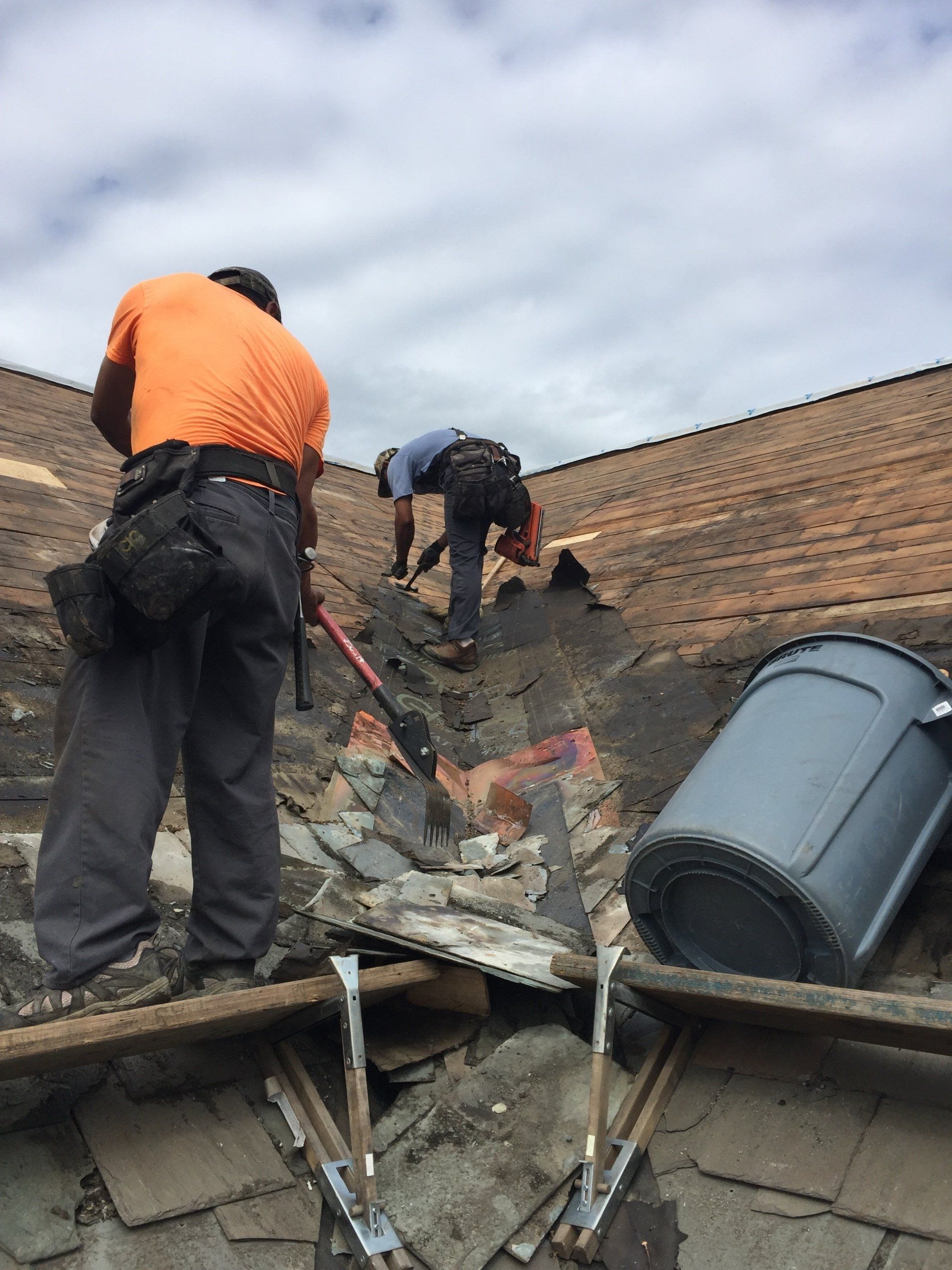 Two men are working on the roof of a building