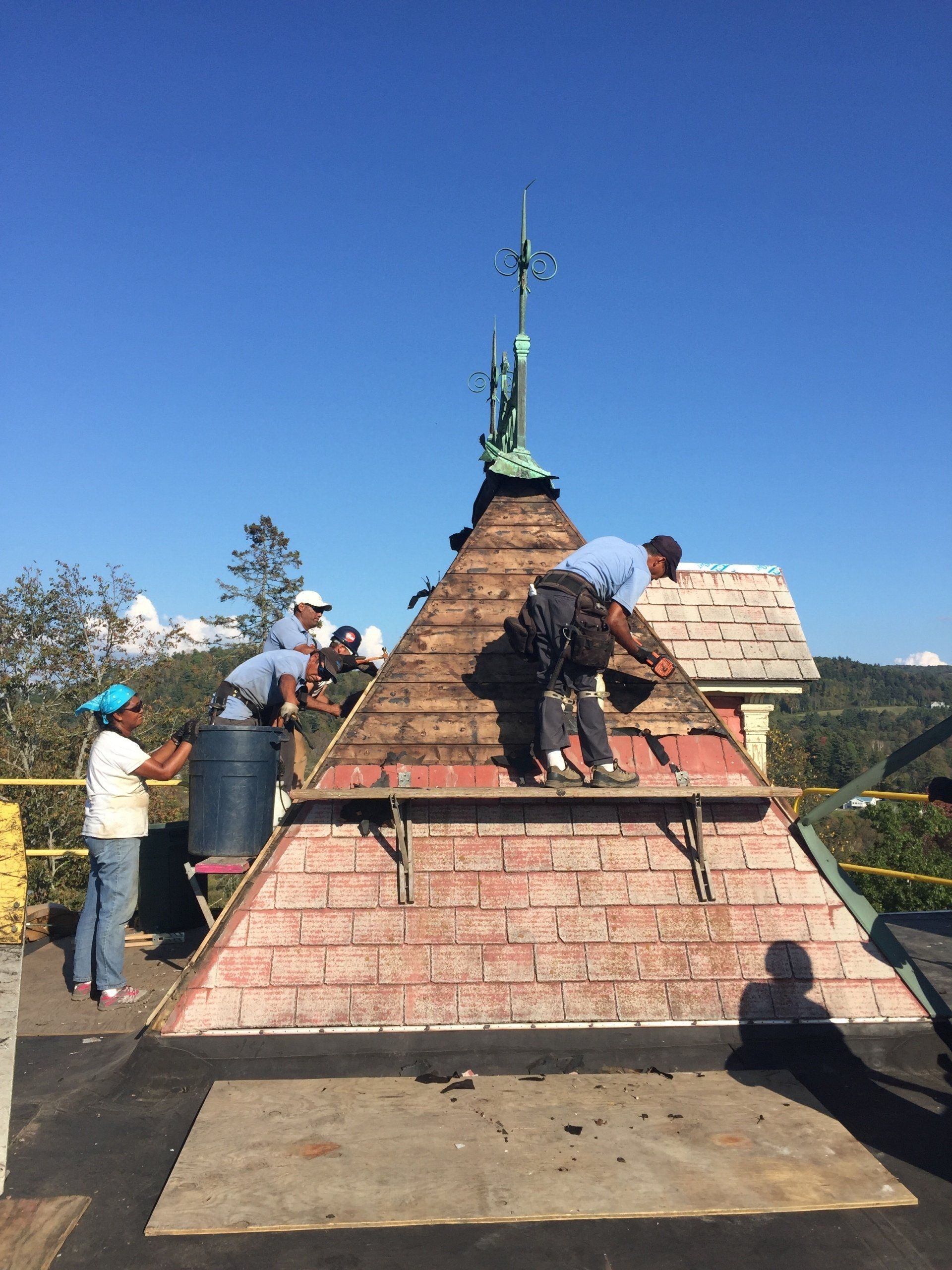 A group of people are working on the roof of a building