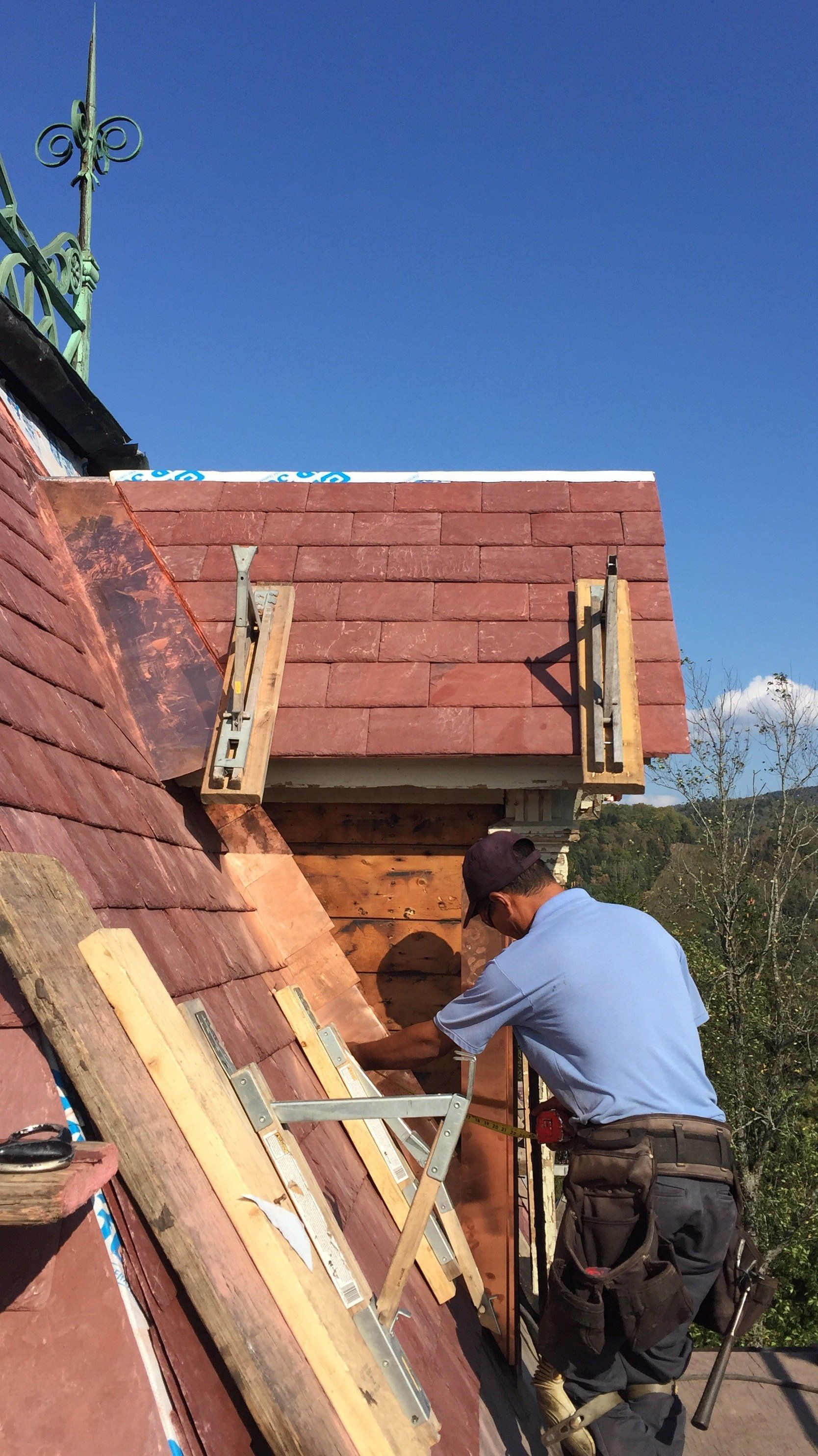 A man is working on the roof of a building.