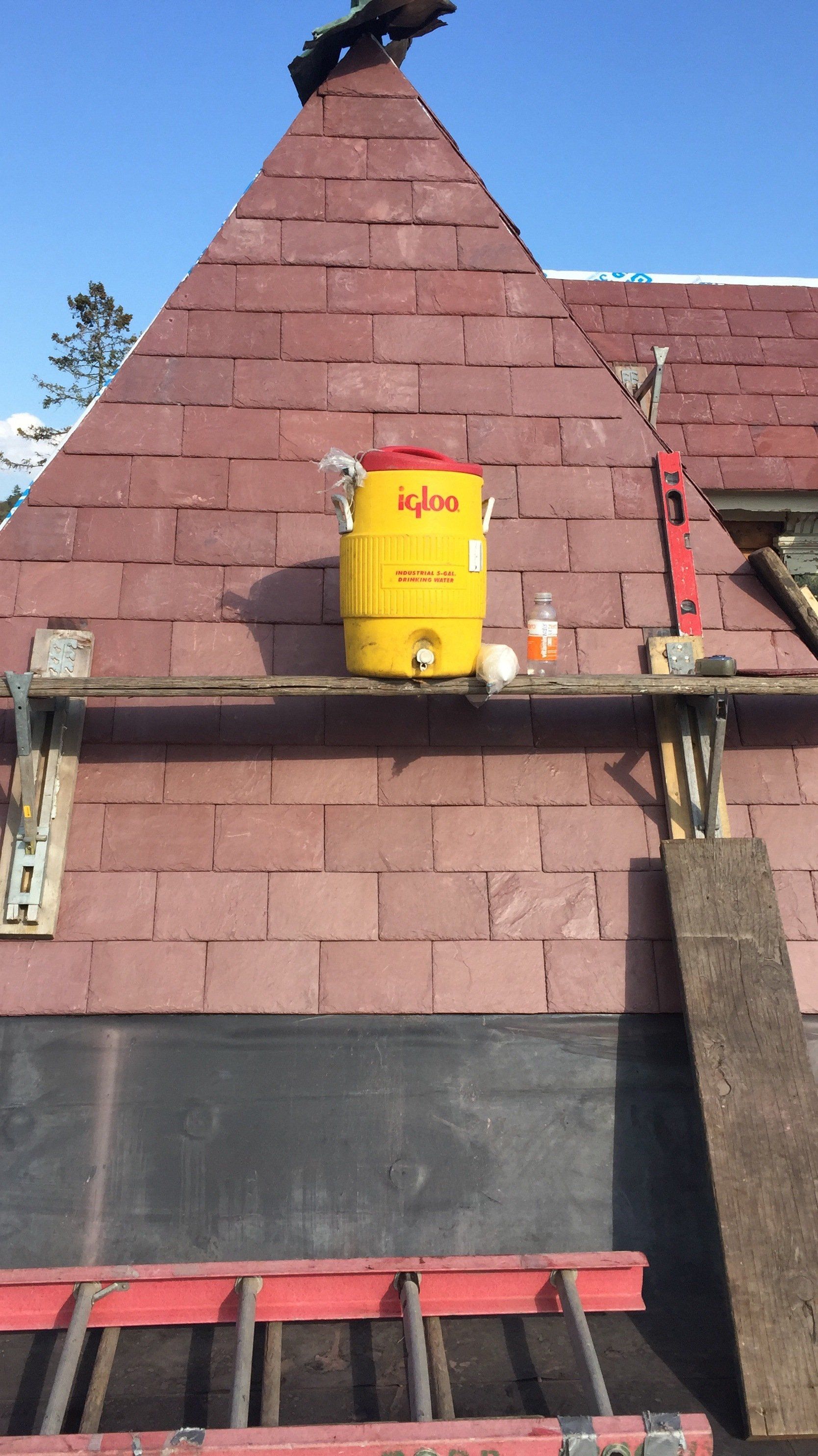 A yellow bucket is sitting on the roof of a building.