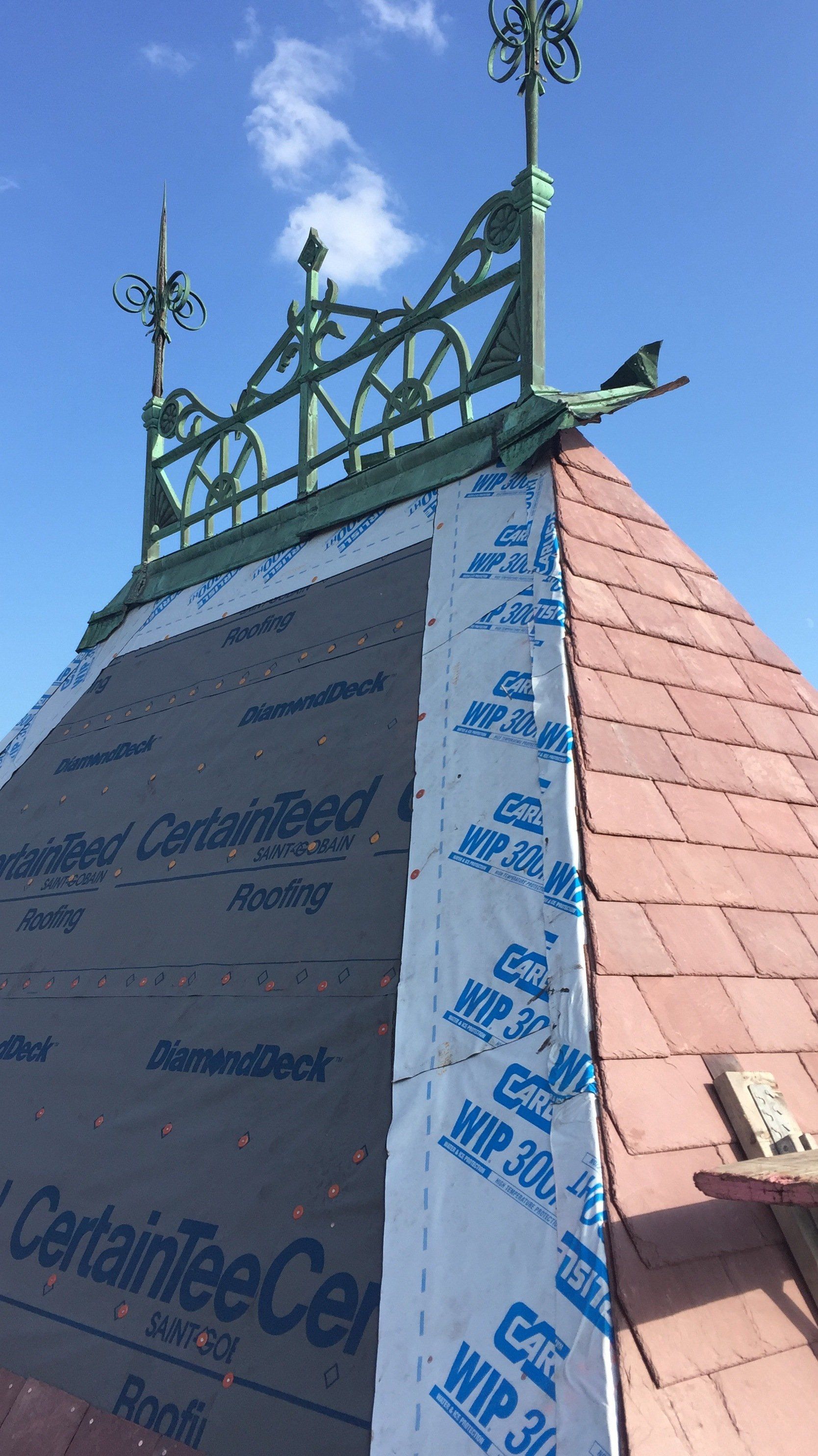 A roof with a weather vane on top of it.