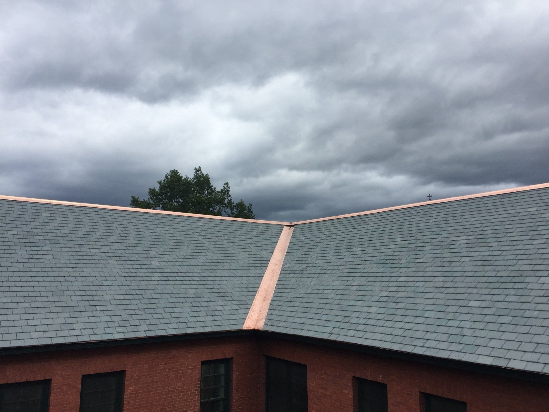 A roof of a building with a cloudy sky in the background