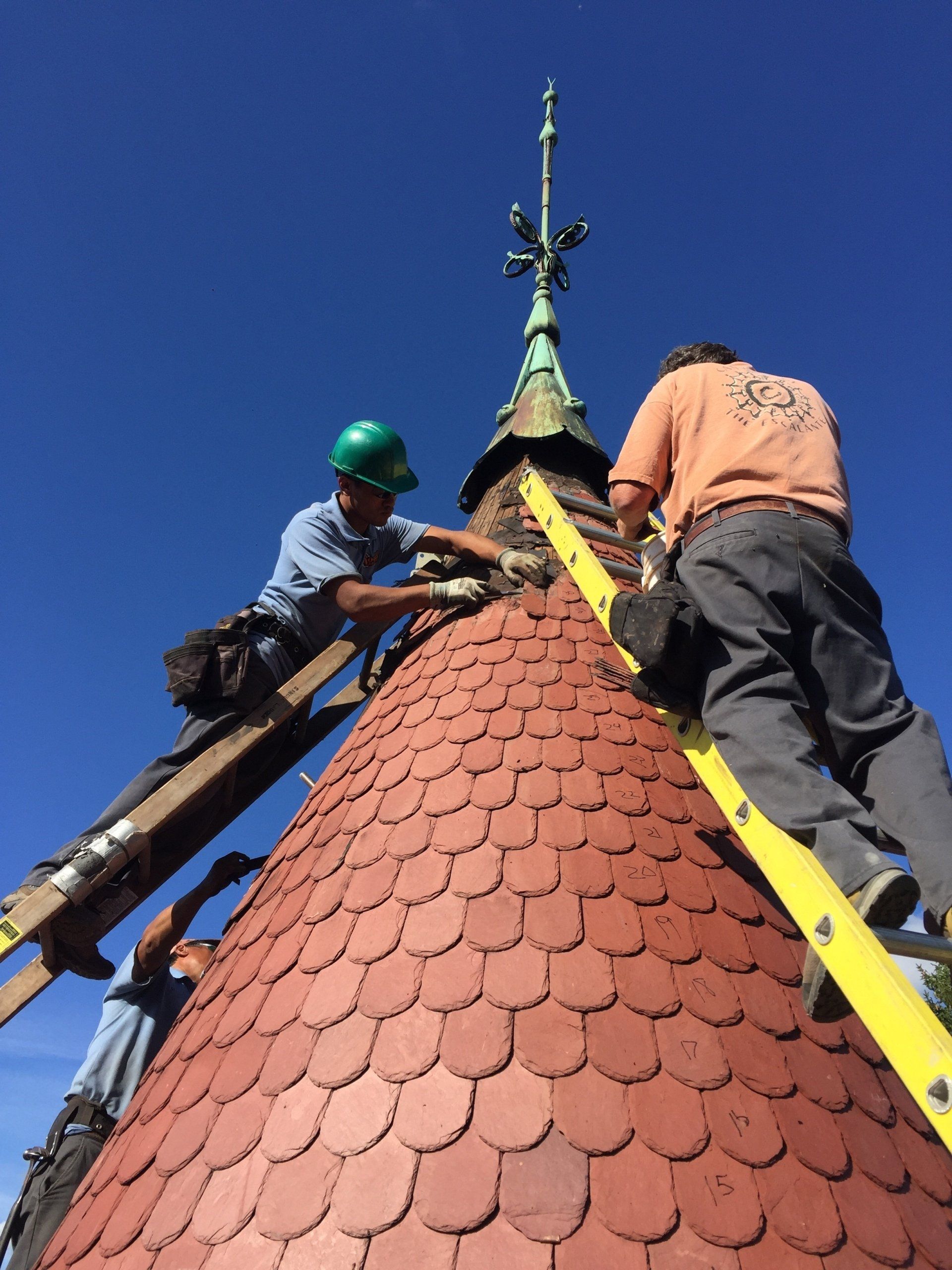 Two men are working on the roof of a building