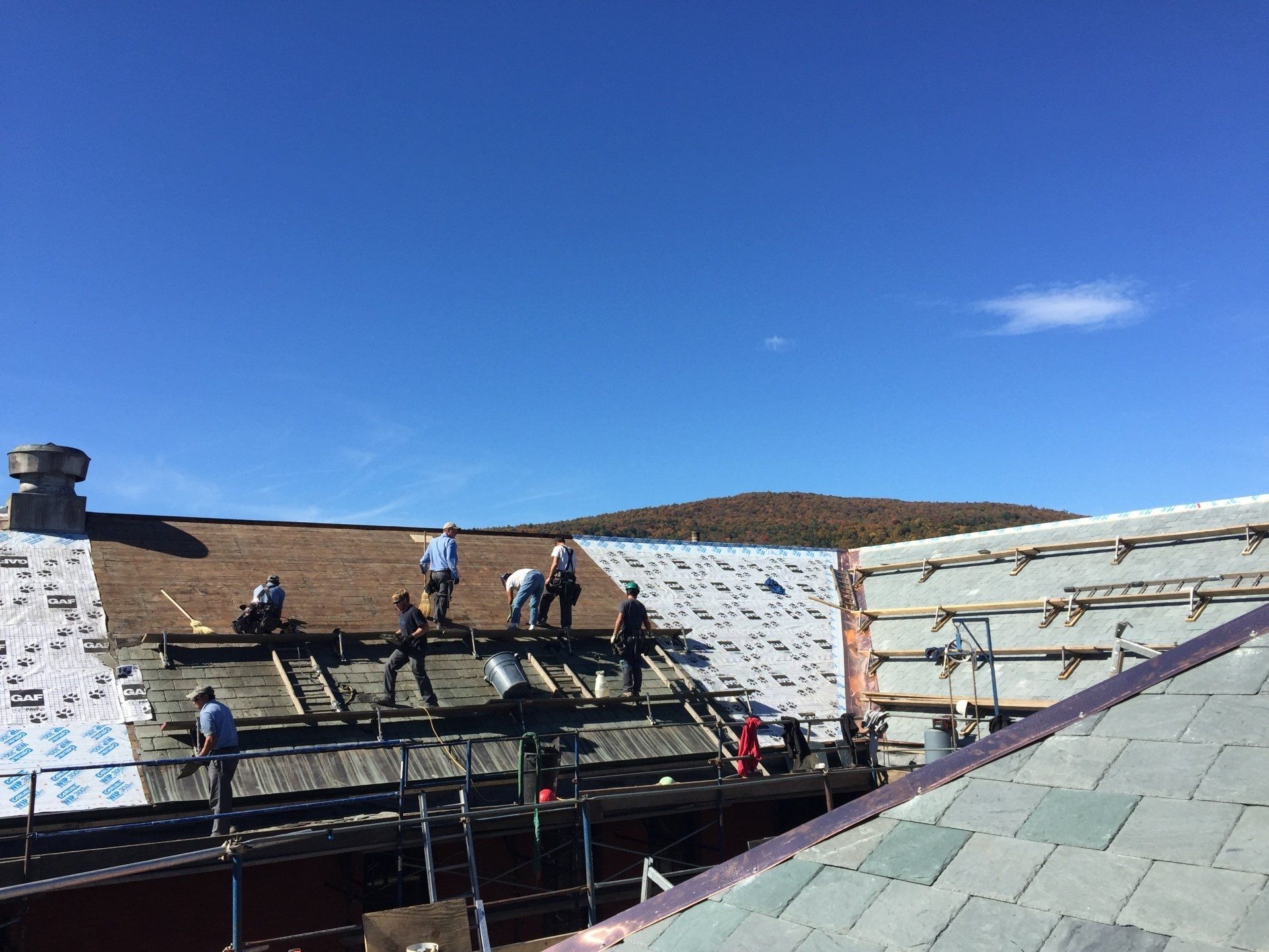 A group of people are working on the roof of a building.