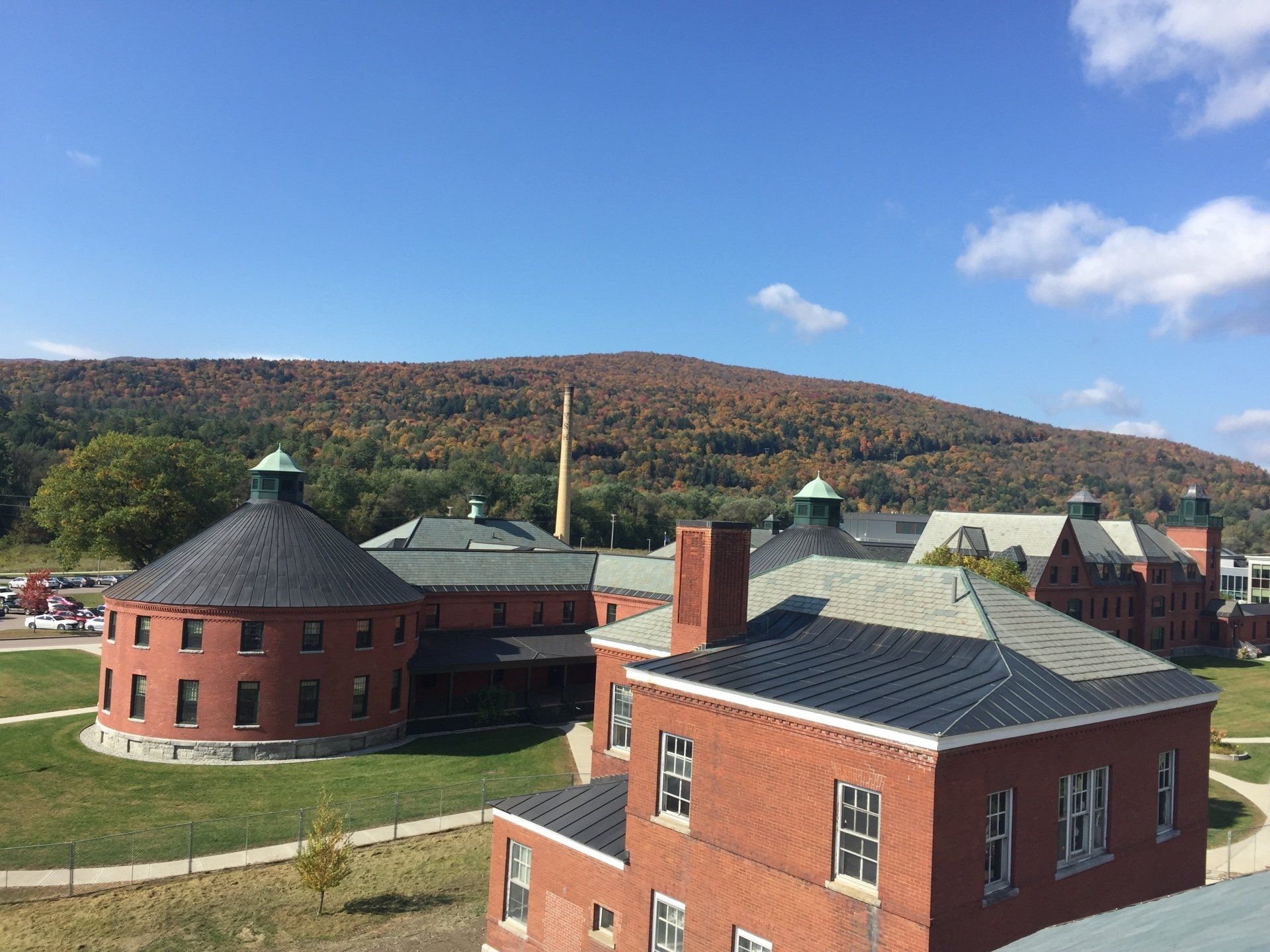 An aerial view of a brick building with a mountain in the background.