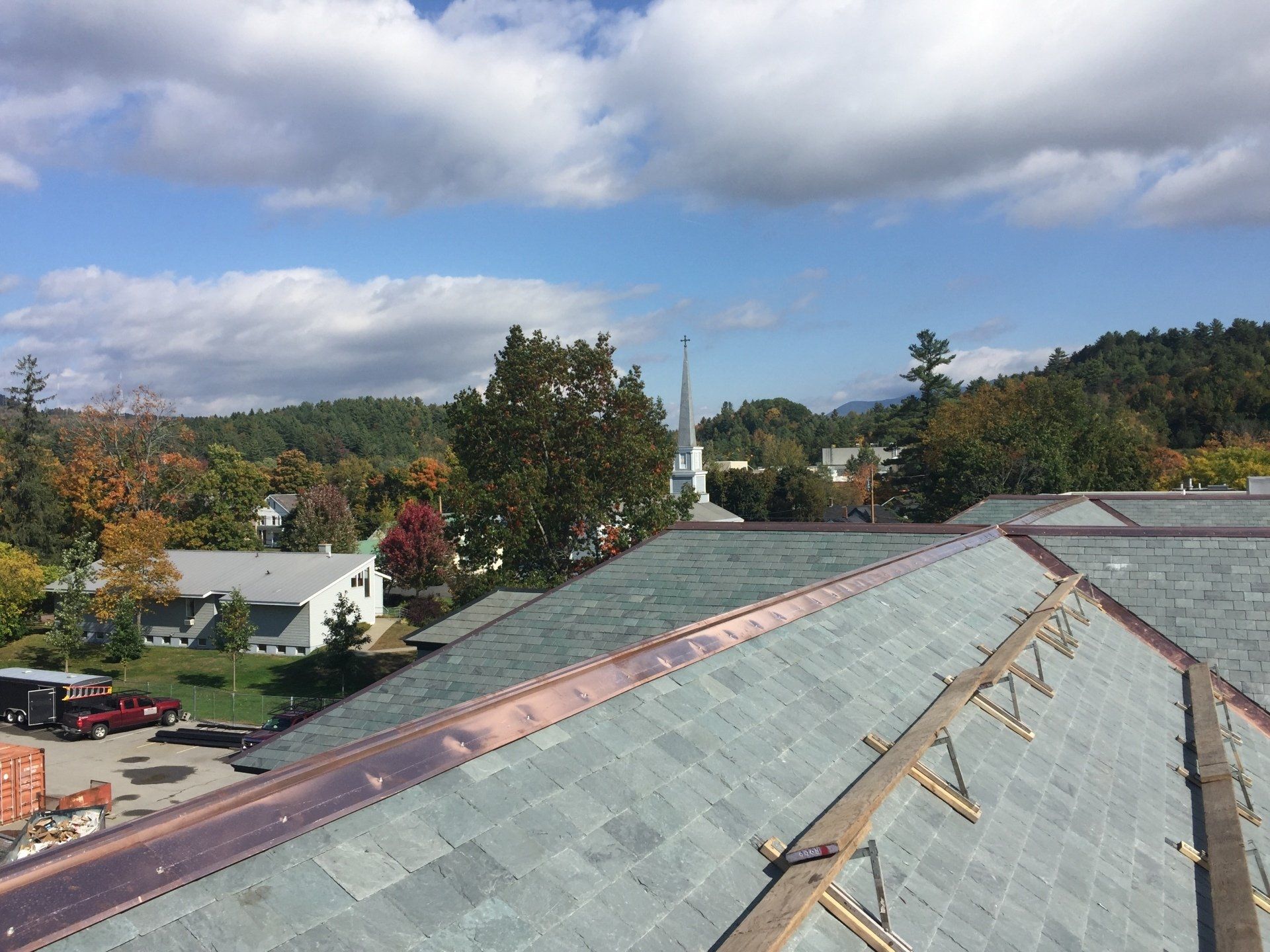 An aerial view of a roof with a church in the background