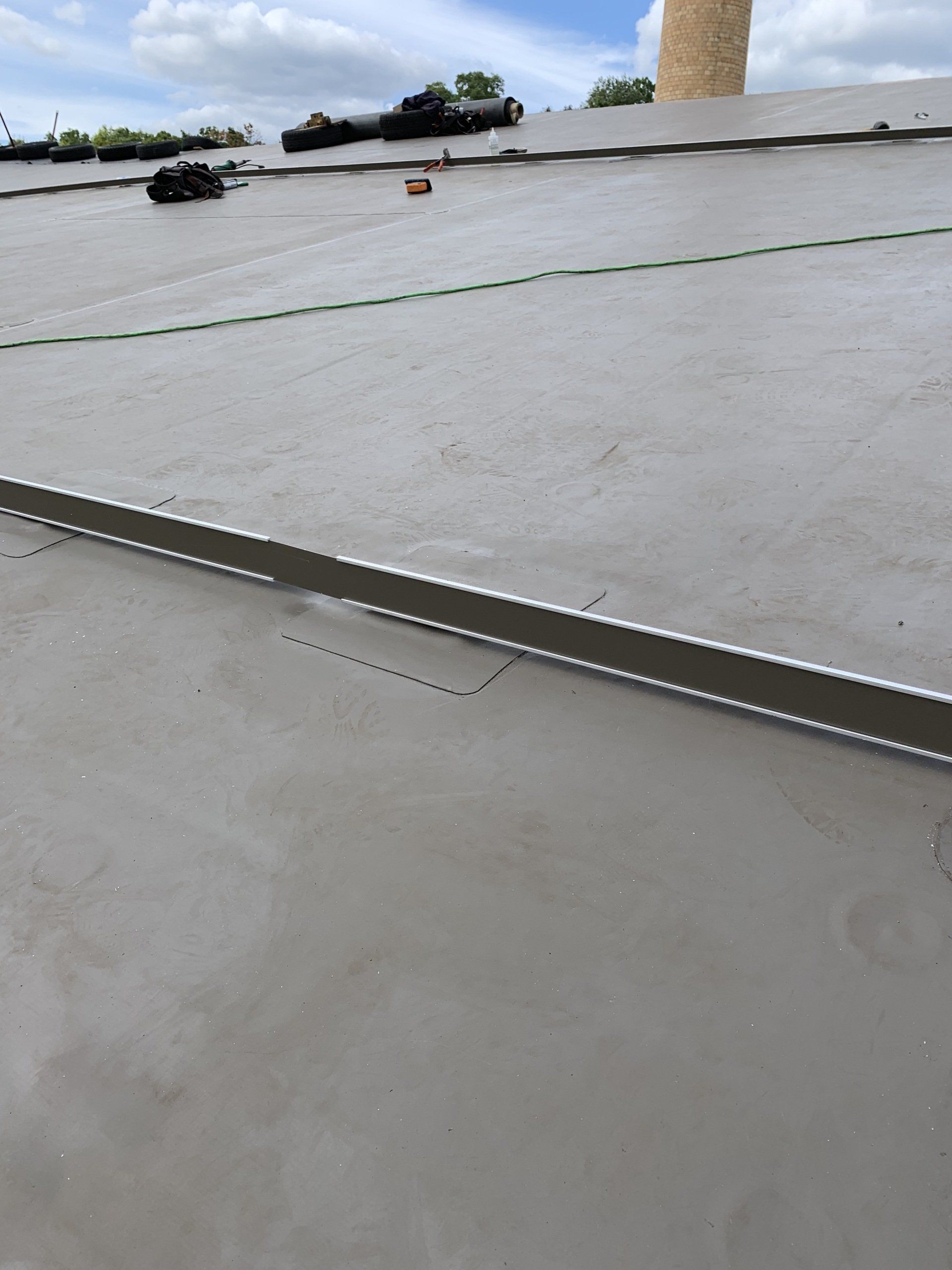 A close up of a roof with a tower in the background