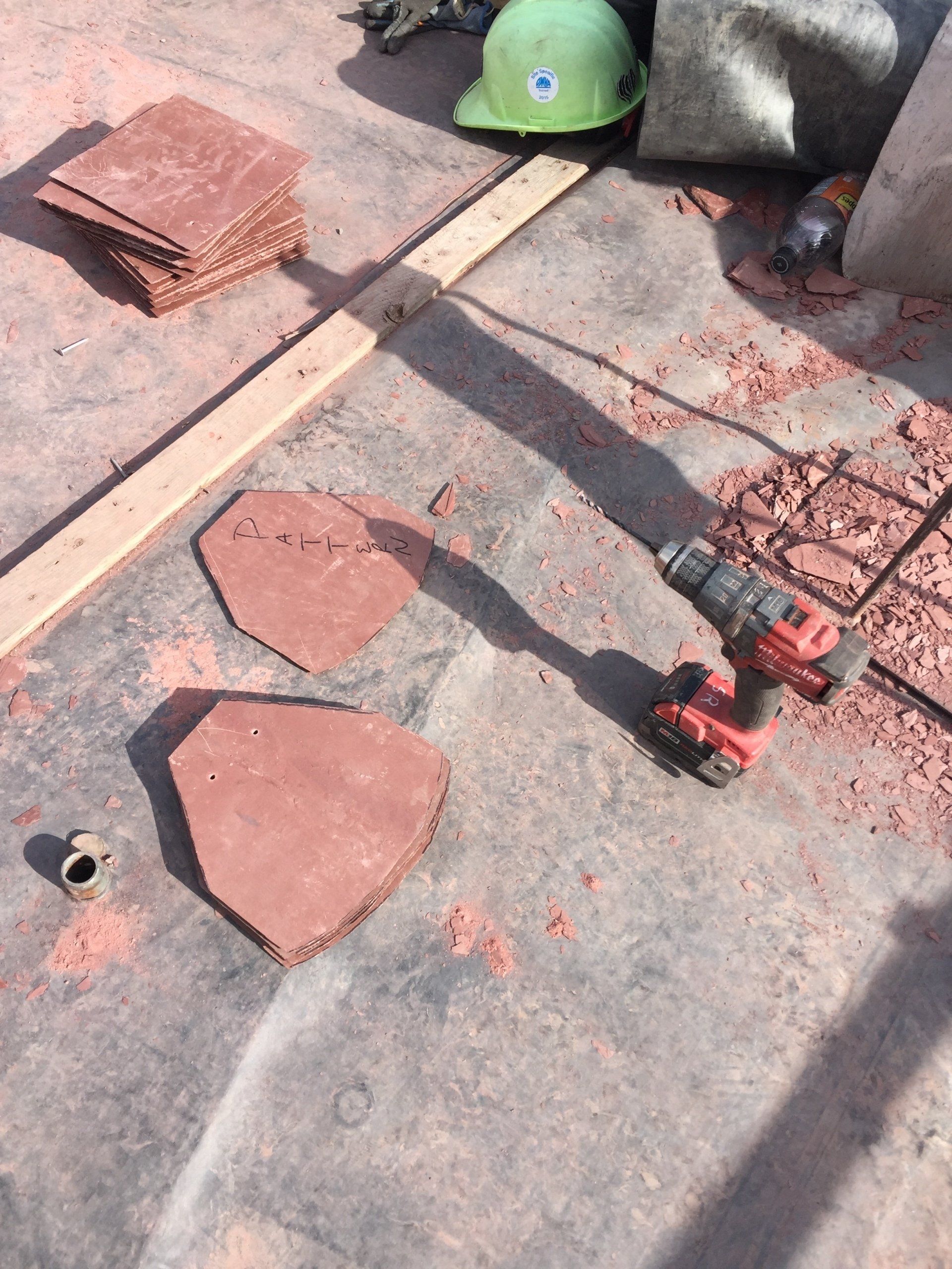 A hard hat and a drill are on the ground