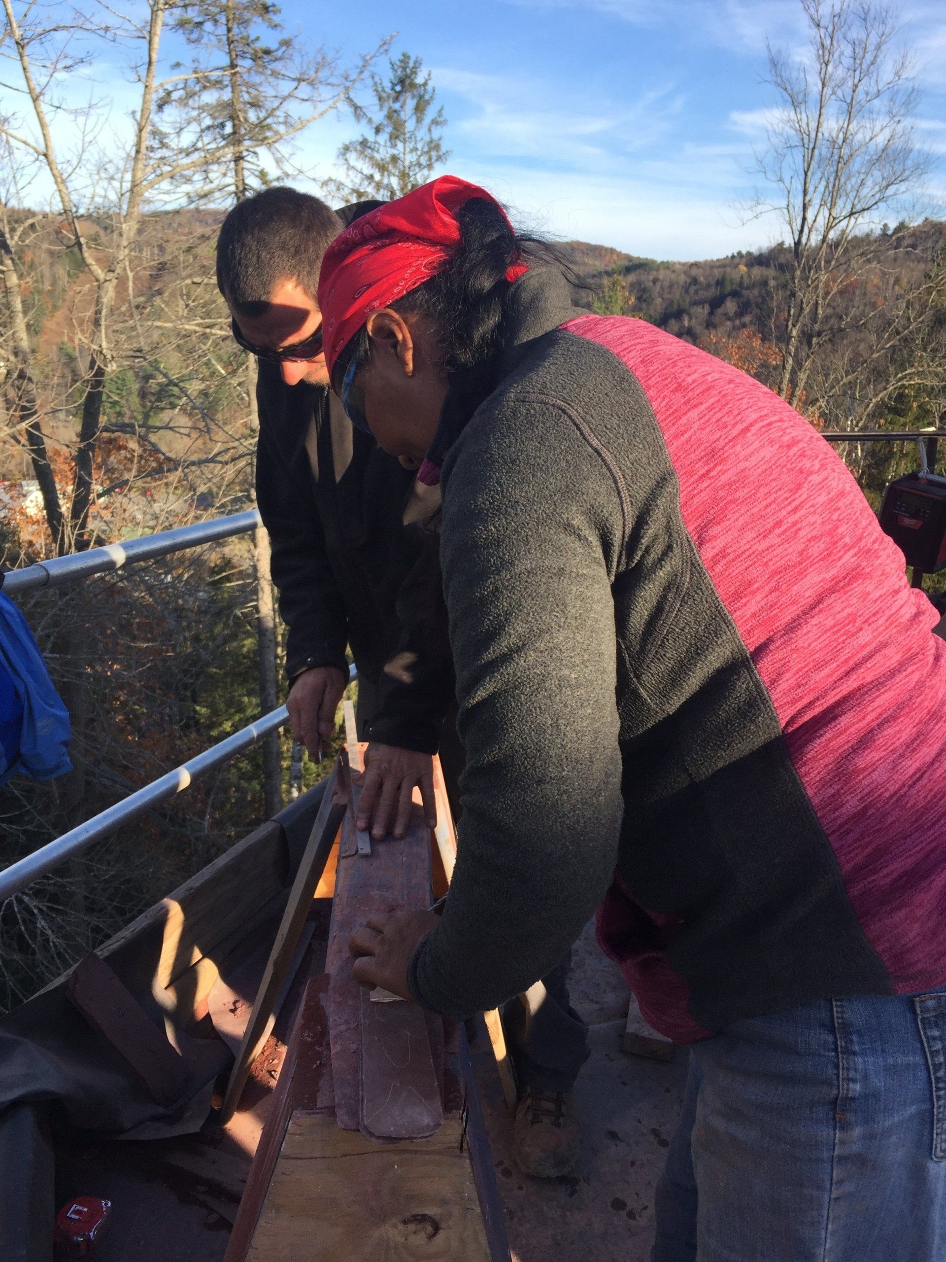 A man and a woman are working on a roof