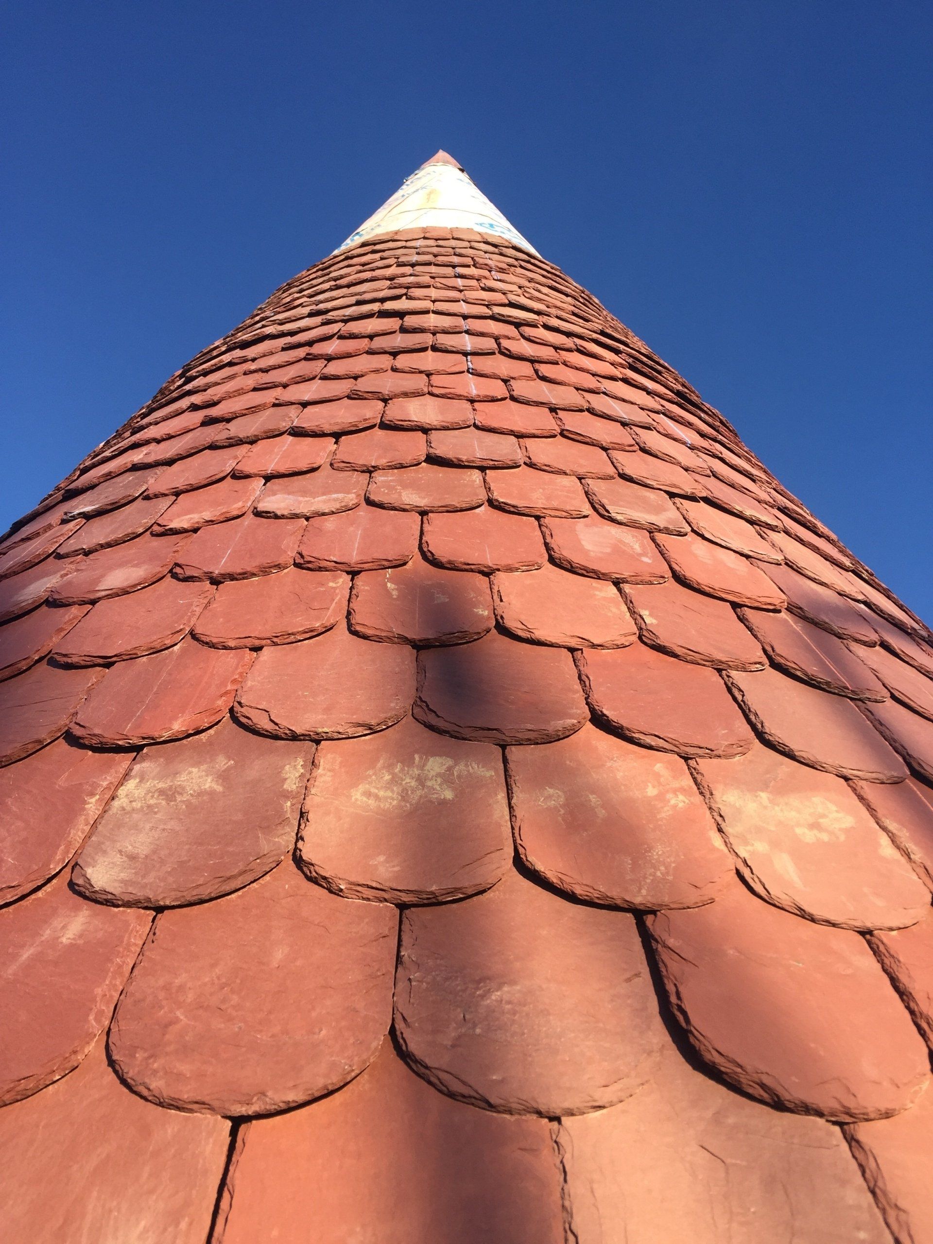 Looking up at the roof of a building with a blue sky in the background