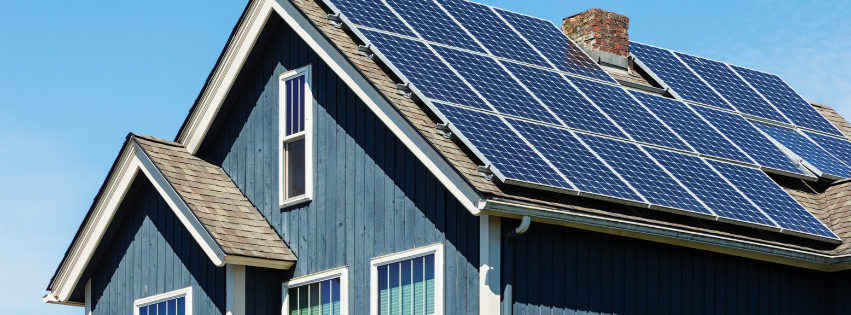 Solar roofing on a home with asphalt shingles under clear blue skies
 