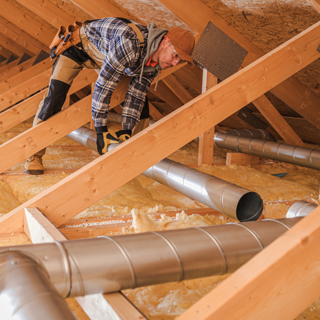 Roofer installing proper ventilation system in the attic of a home.