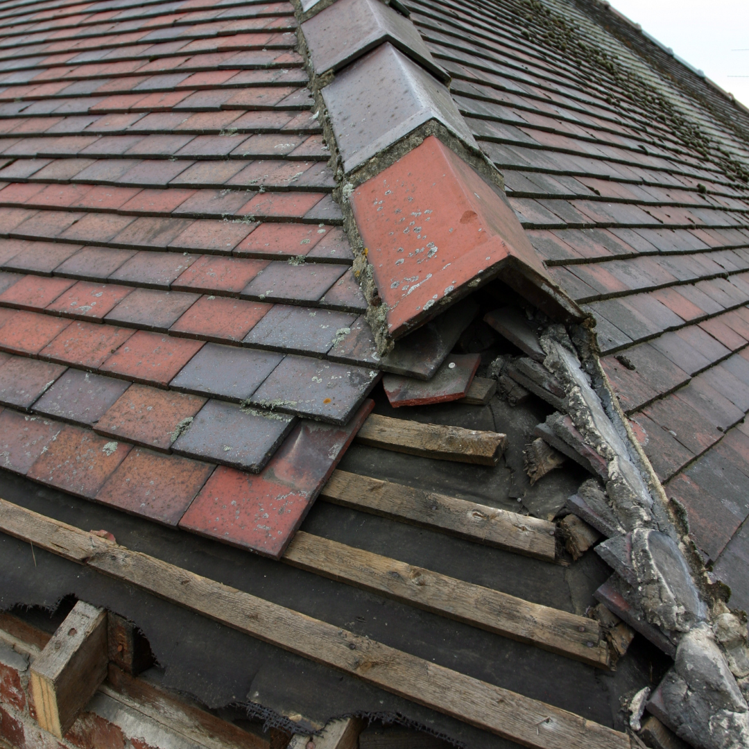 A roof with slate shingles in need of repair