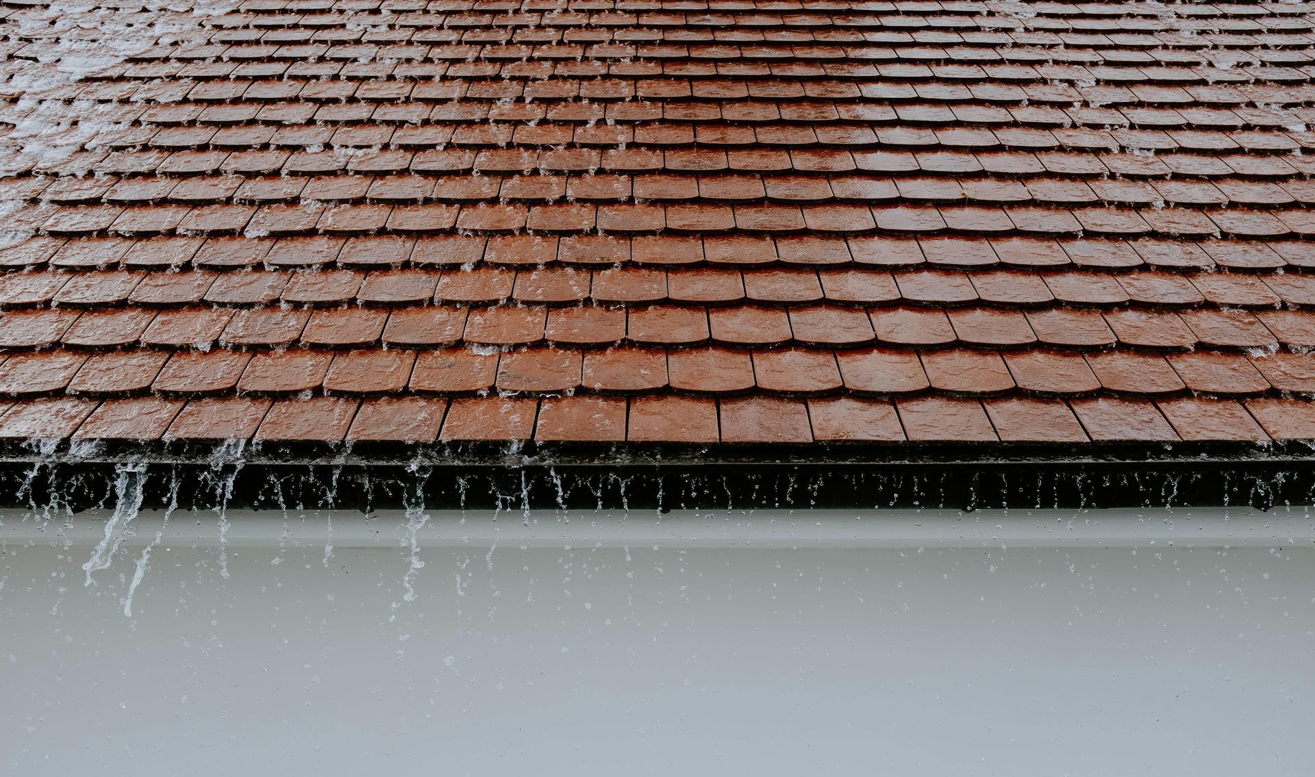 Rain pours off a Vermont roof during hurricane season