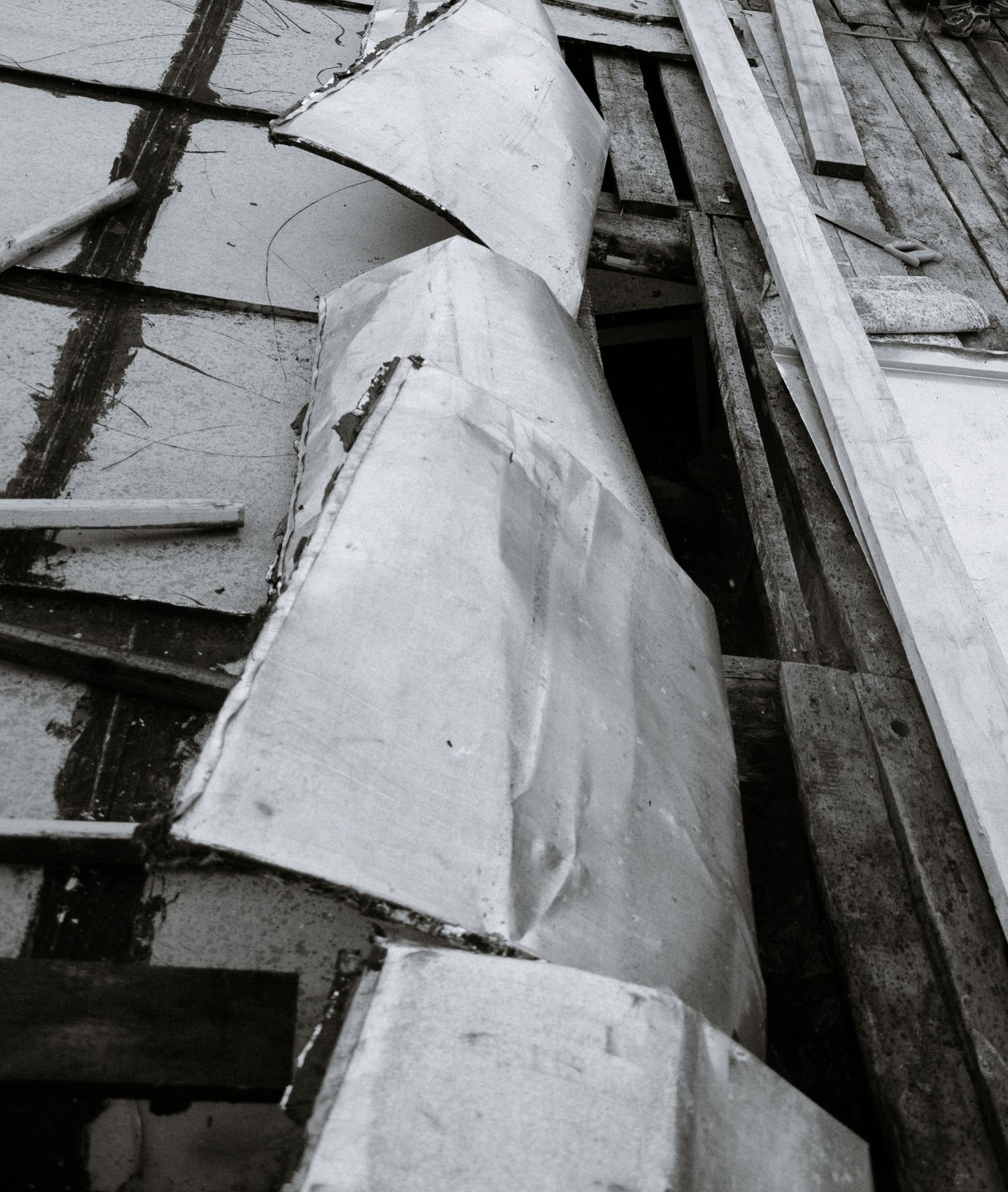 A black and white photo of a roof that has undergone significant damage